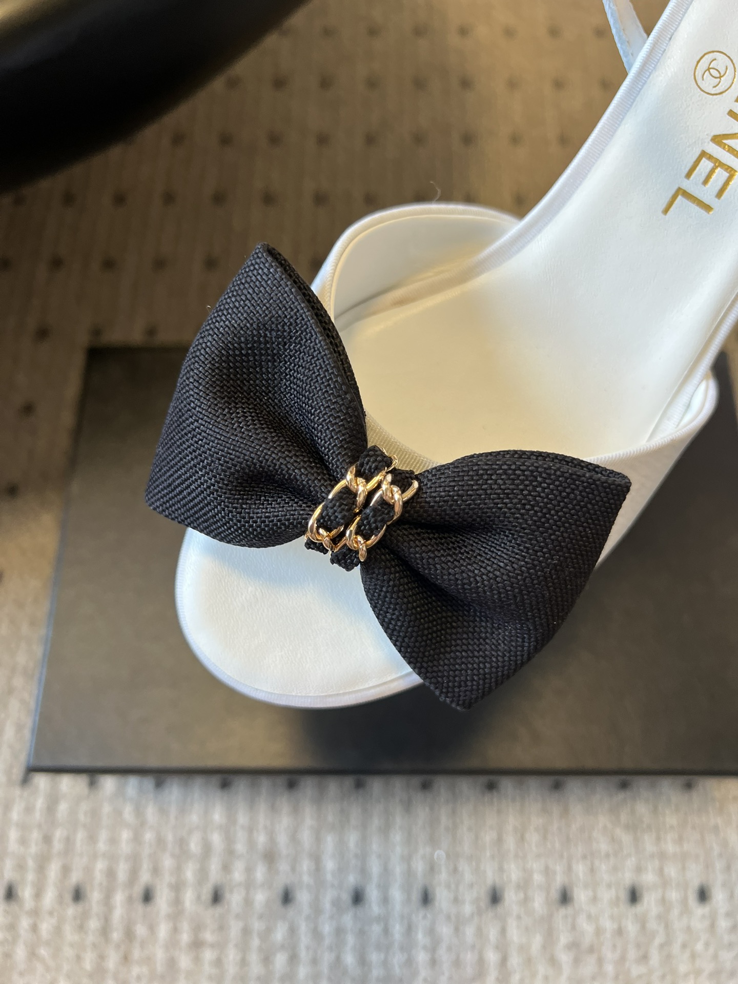 Chane*26ss低跟细踝带蝴蝶结凉鞋鞋身以标志性蝴蝶结为核心装饰，部分蝴蝶结处点缀品牌经典的双C金属