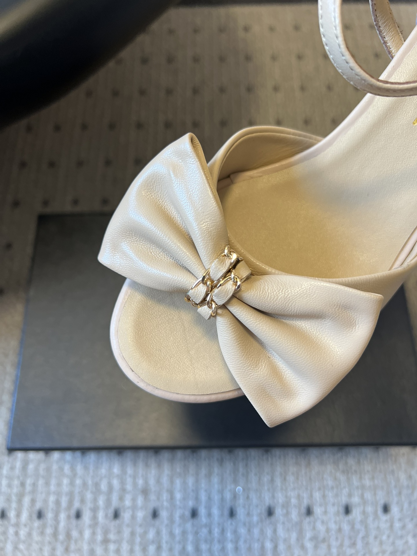 Chane*26ss低跟细踝带蝴蝶结凉鞋鞋身以标志性蝴蝶结为核心装饰，部分蝴蝶结处点缀品牌经典的双C金属