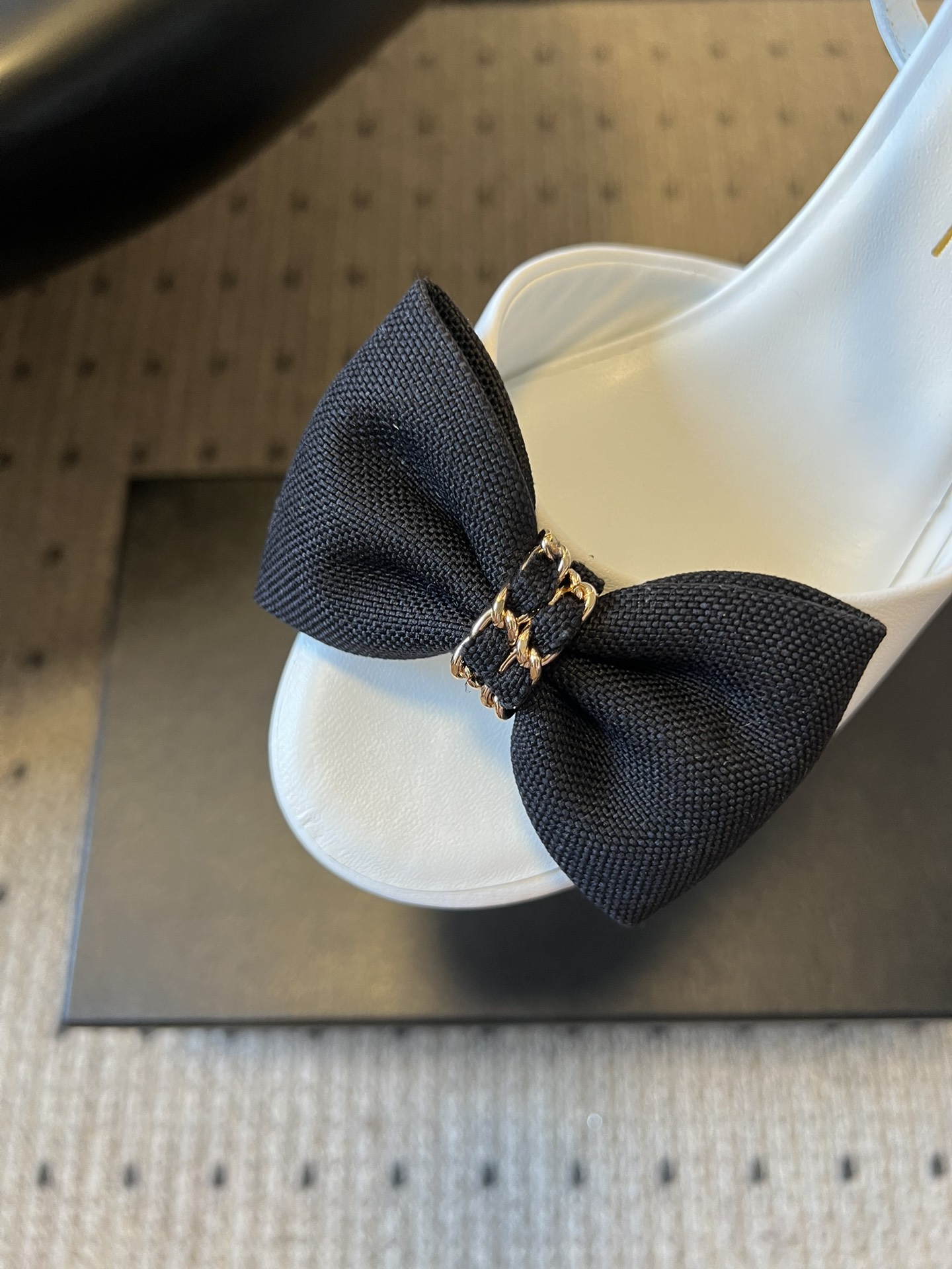 Chane*26ss低跟细踝带蝴蝶结凉鞋鞋身以标志性蝴蝶结为核心装饰，部分蝴蝶结处点缀品牌经典的双C金属