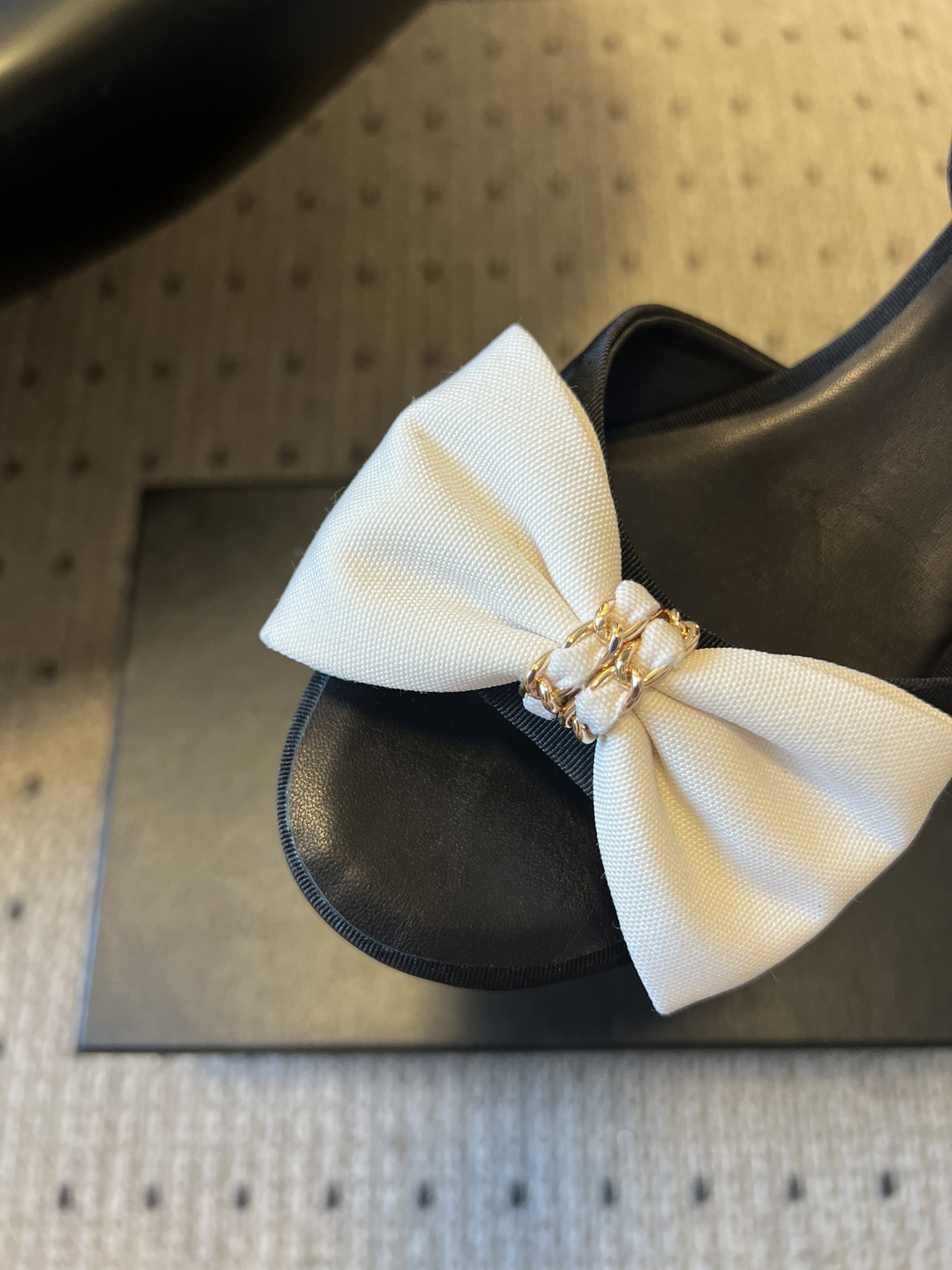 Chane*26ss低跟细踝带蝴蝶结凉鞋鞋身以标志性蝴蝶结为核心装饰，部分蝴蝶结处点缀品牌经典的双C金属