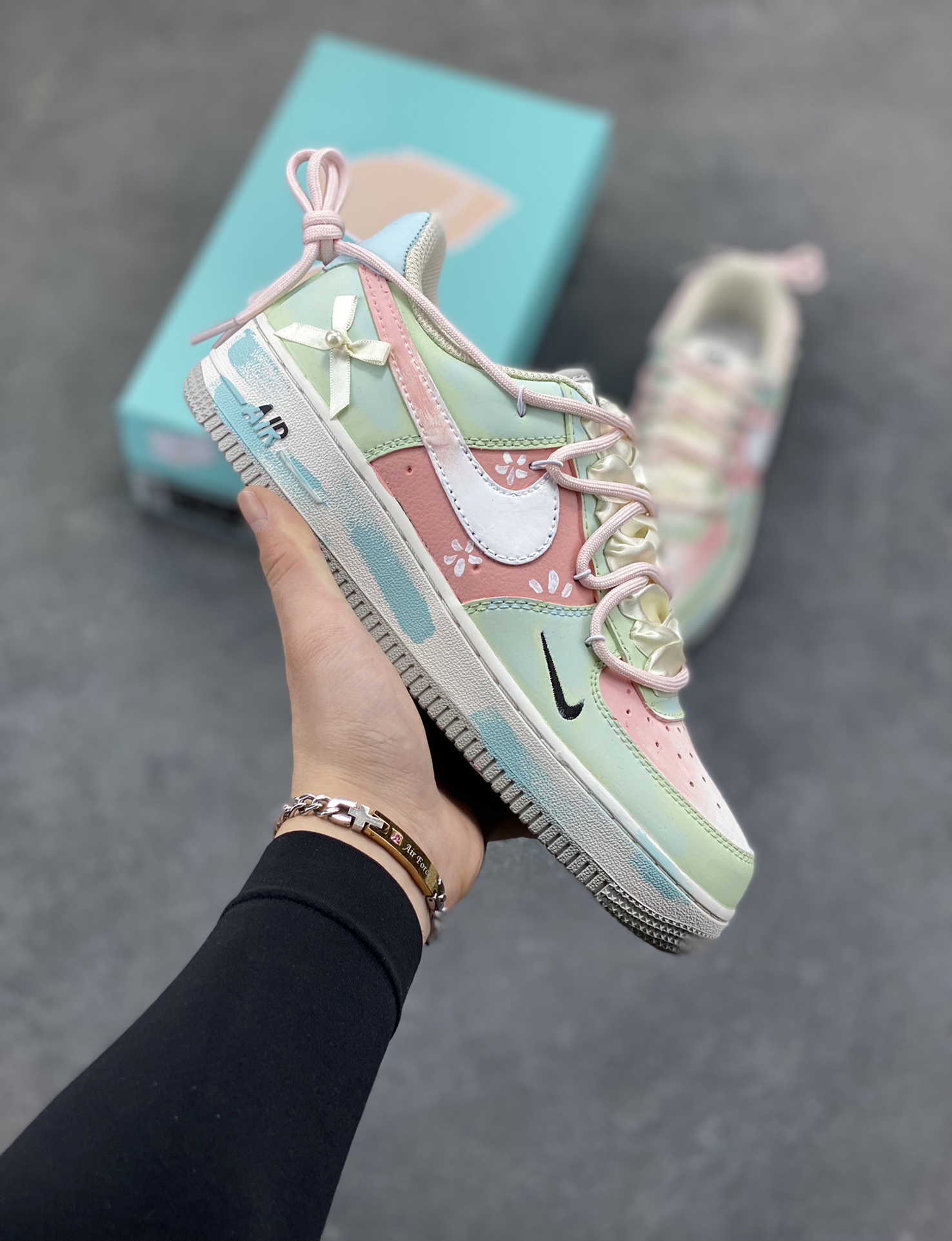 手绘涂鸦“粉樱薄荷”Nike Air Force 1 “Pink Cherry & Mint”空军一号定制板鞋 把春日的 “粉樱 + 薄荷” 揉进了鞋里：淡粉与薄荷绿的撞色清透又软甜，鞋身的小碎花与缎带蝴蝶结戳中少女心，鞋边的水彩晕染自带松弛的手绘质感，连双勾设计都藏着细腻巧思。像咬开一颗裹着樱花香的薄荷糖，甜而不腻，是把 “春日软萌” 穿在脚上的氛围感单品 货号：FB1839-818 尺码： 36 36.5 37.5 38 38.5 39 40-选品中心