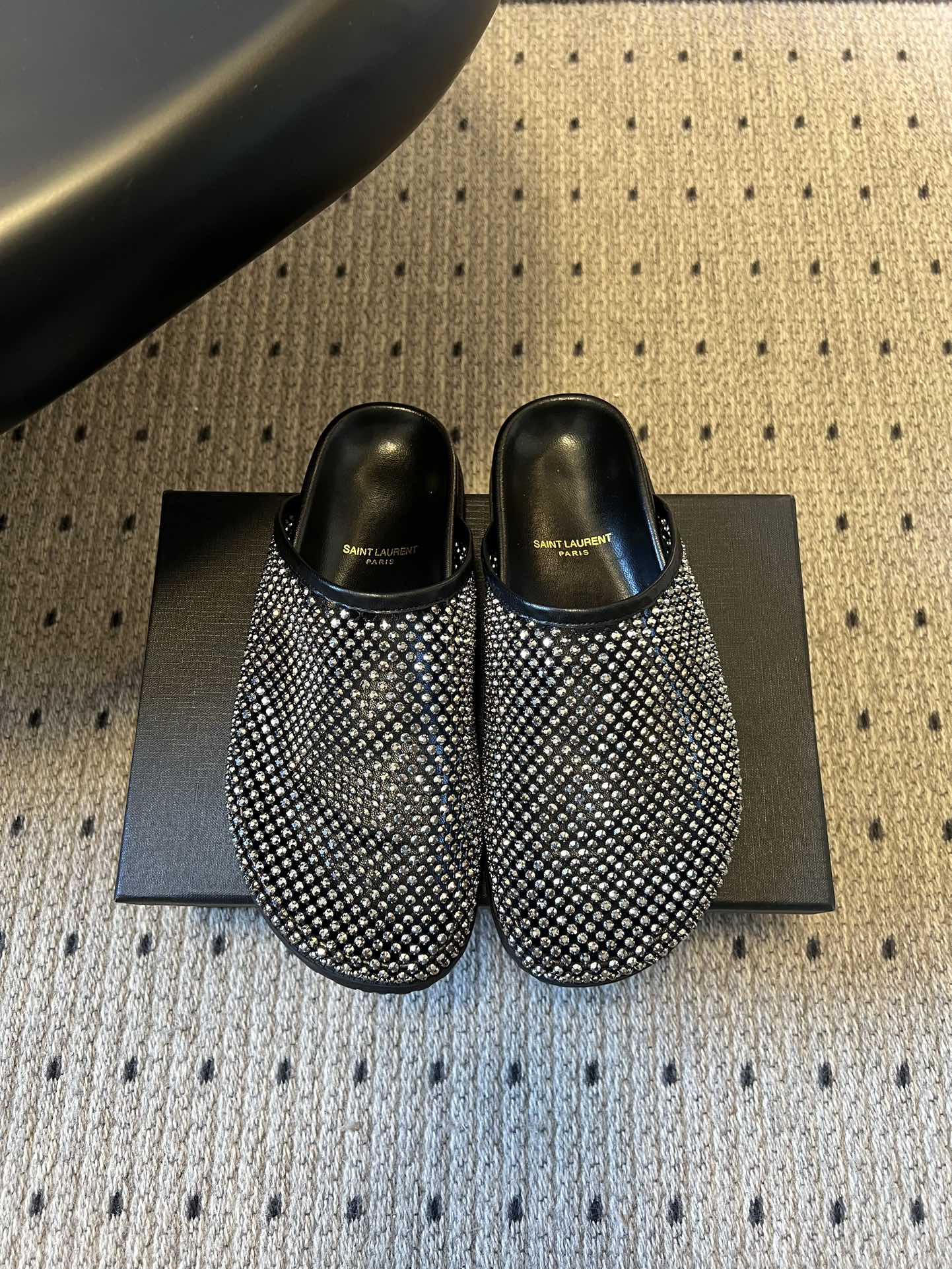 NO:682485,Saintlauren*25ss autumn and winter diamond-faced mules half-slipper casual shoes. The upper is covered with rhinestone decoration, and the diamond face design is arranged in a grid, which has a strong luster. It is launched in two colors: gold and black. The golden shoe body and the lining are the same color, and the black style has a rhinestone face with a black leather lining, which has a sharp visual contrast.  It is a toe-toe Mule half-mug style with no heel design, making it easy to put on and take off with one foot. The shoe shape is a simple flat-bottomed toe-toe style with smooth lines, taking into account practicality and style. The YSL brand logo can be seen inside the shoe, and it uses leather lining and textured sole, continuing the light luxury and exquisite craftsmanship of Yves Saint Laurent, with both fashion and brand recognition. The upper is meshed with mesh, and the lining is sheepskin. The outsole is 2cm taller.  Size 35-40 (customized size 40 is non-refundable, semi-trailer, saint laurent, saint laurent, saint laurent, slippers, sheepskin19860909Saintlauren*25ss秋冬钻面穆勒半拖鞋休闲鞋 鞋面通体覆盖水钻装饰,采用网格状排列的钻面设计,光泽感强；推出金色、黑色两款配色,金色款鞋身与内里同色,黑色款钻面搭配黑色皮质内里,视觉对比鲜明. 为包头穆勒拖半拖款式,无后跟设计,一脚蹬穿脱便捷；鞋型为简约的平底包头款,线条流畅,兼顾实用性与造型感.鞋内可见YSL品牌标识,采用皮革内里与质感鞋底,延续了圣罗兰轻奢精致的工艺水准,兼具时尚度与品牌辨识度. 鞋面网钻 内里羊皮 大底橡胶大底 增高2cm size35-40码（40码定制不退换,半拖,saint laurent,saint laurent,saint laurent,slippers,sheepskin,Women's Shoes