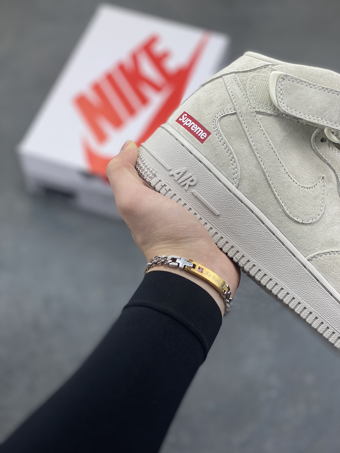 图片[6]-街头典藏款文案浅灰麂皮的温柔暴击，是Supreme与Nike Air Force 1 Mid的联名浪漫！DV0788-001鞋款以细腻翻毛皮革重塑经典中帮鞋型，鞋侧红标、挂饰徽章的品牌标识撞出街头辨识度，魔术贴绑带可自由调节的设计，让搭配多了几分玩趣。Air气垫加持的经典大底，踩出云端般的脚感，把美式复古的慵懒与潮酷揉进每一步，这双“非Dunk却胜Dunk”的联名款，是街头玩家鞋柜里的收藏级狠货！-选品中心