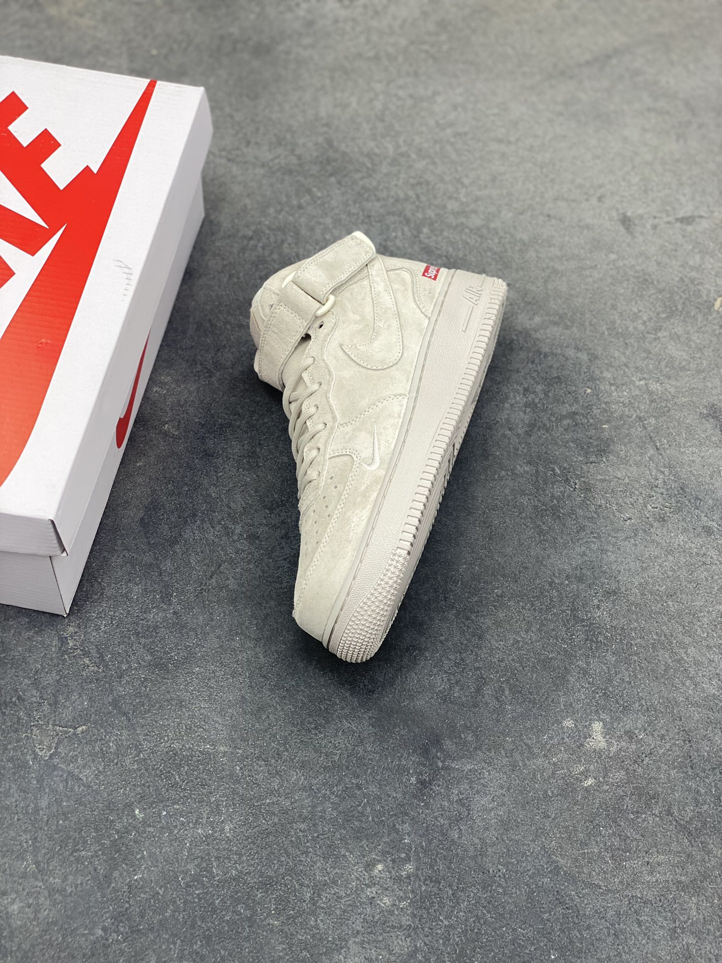 图片[7]-街头典藏款文案浅灰麂皮的温柔暴击，是Supreme与Nike Air Force 1 Mid的联名浪漫！DV0788-001鞋款以细腻翻毛皮革重塑经典中帮鞋型，鞋侧红标、挂饰徽章的品牌标识撞出街头辨识度，魔术贴绑带可自由调节的设计，让搭配多了几分玩趣。Air气垫加持的经典大底，踩出云端般的脚感，把美式复古的慵懒与潮酷揉进每一步，这双“非Dunk却胜Dunk”的联名款，是街头玩家鞋柜里的收藏级狠货！-选品中心