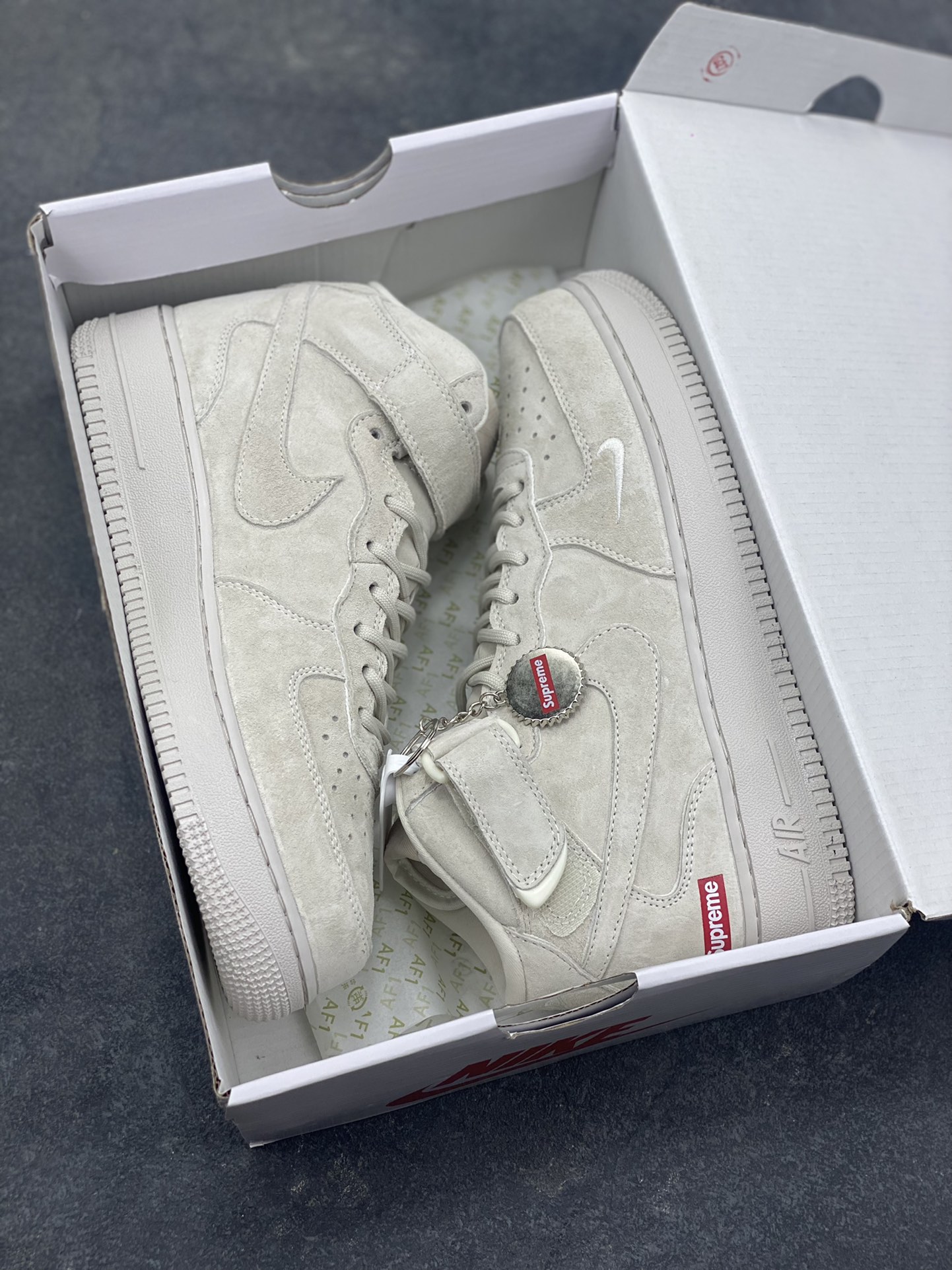 图片[9]-街头典藏款文案浅灰麂皮的温柔暴击，是Supreme与Nike Air Force 1 Mid的联名浪漫！DV0788-001鞋款以细腻翻毛皮革重塑经典中帮鞋型，鞋侧红标、挂饰徽章的品牌标识撞出街头辨识度，魔术贴绑带可自由调节的设计，让搭配多了几分玩趣。Air气垫加持的经典大底，踩出云端般的脚感，把美式复古的慵懒与潮酷揉进每一步，这双“非Dunk却胜Dunk”的联名款，是街头玩家鞋柜里的收藏级狠货！-选品中心