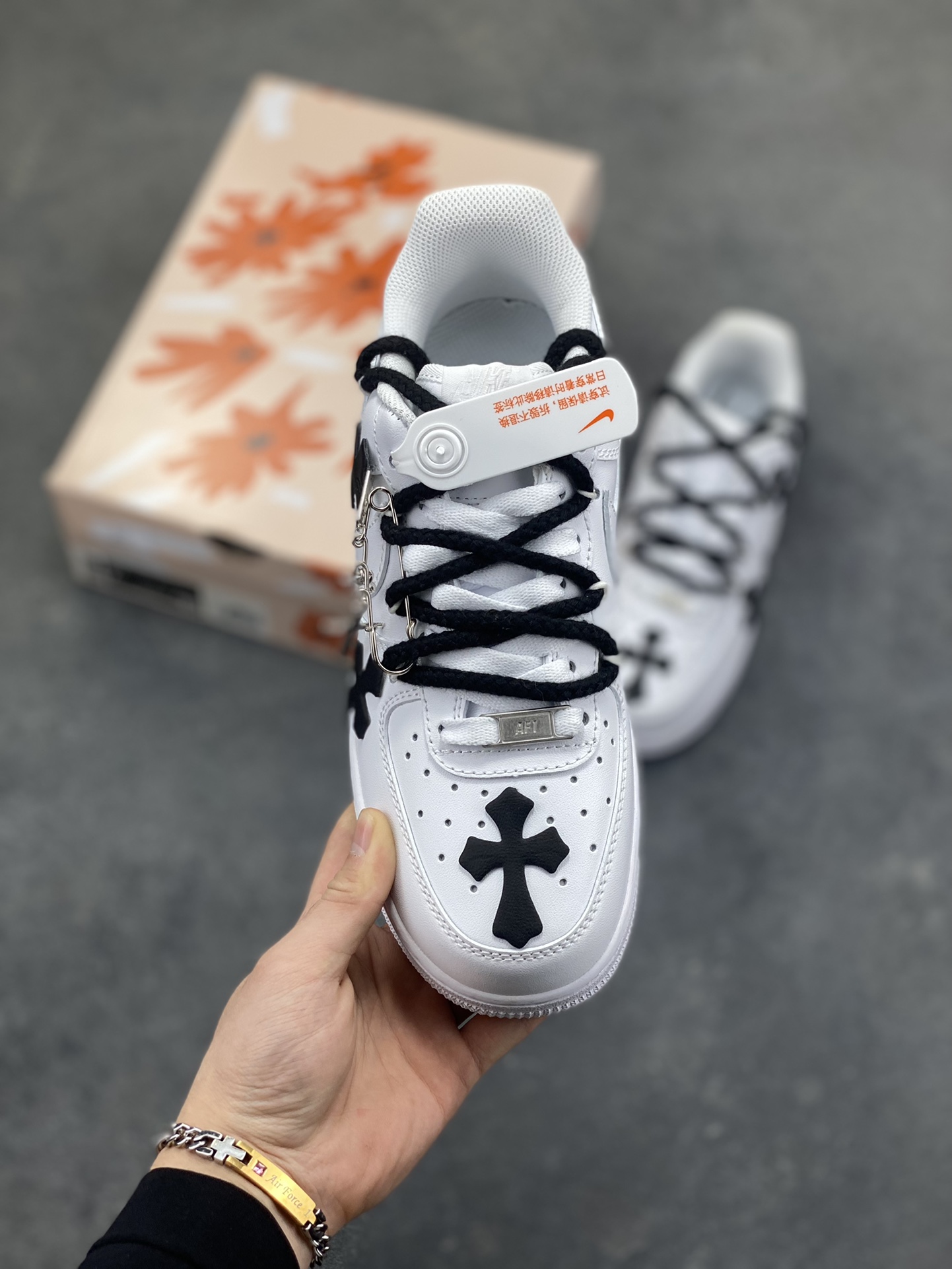 图片[2]-“十字星芒”✨订制空军一号板鞋 该定制版球鞋选用原鞋款为Nike Air Force 1‘07空军一号，鞋身大面积点缀黑色克罗心风格十字花元素，黑白撞色形成强烈视觉冲击，成为最亮眼的设计标识。替换成黑色粗鞋带，搭配金属十字挂饰等配饰，打破了纯白空军一号的简约感，强化了定制的独特性。 货号：CW2288-111 尺码： 36 36.5 37.5 38 38.5 39 40 40.5 41 42 42.5 43 44 44.5 45-选品中心