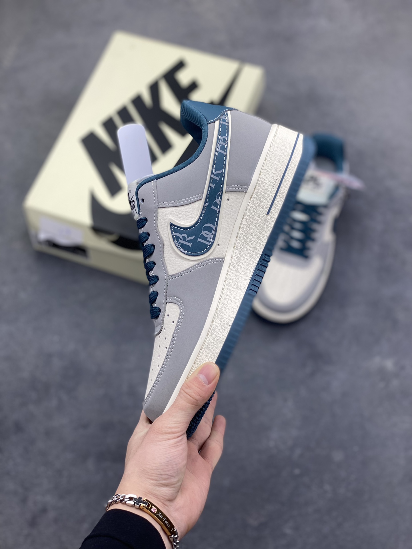 图片[3]-格调碰撞，经典新生！当Nike Air Force 1的街头基因遇上Dior的高奢美学，这双Air Force 1 Low DD1928-313完成了一次惊艳的风格跨界。高级灰调为主的鞋身，搭配深海蓝的撞色点缀，皮质拼接的质感扑面而来。Swoosh标志上的Dior字母印花、鞋侧的品牌标识，将奢华细节融入经典鞋型，小勾设计更是暗藏巧思。米白中底搭配蓝调外底，延续AF1的复古轮廓，又赋予了全新的视觉层次。无论是日常出街的随性搭配，还是打造高街奢潮造型，这双鞋都能成为造型的点睛之笔，让经典鞋款在奢潮融合中焕发全新魅力。-选品中心