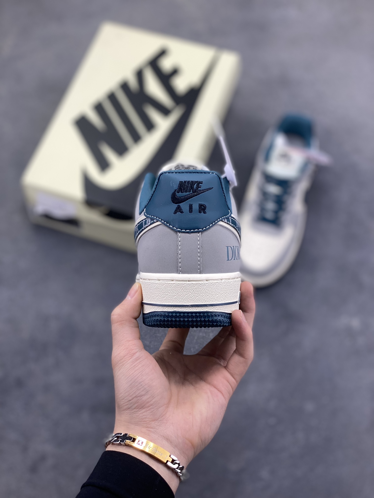 图片[4]-格调碰撞，经典新生！当Nike Air Force 1的街头基因遇上Dior的高奢美学，这双Air Force 1 Low DD1928-313完成了一次惊艳的风格跨界。高级灰调为主的鞋身，搭配深海蓝的撞色点缀，皮质拼接的质感扑面而来。Swoosh标志上的Dior字母印花、鞋侧的品牌标识，将奢华细节融入经典鞋型，小勾设计更是暗藏巧思。米白中底搭配蓝调外底，延续AF1的复古轮廓，又赋予了全新的视觉层次。无论是日常出街的随性搭配，还是打造高街奢潮造型，这双鞋都能成为造型的点睛之笔，让经典鞋款在奢潮融合中焕发全新魅力。-选品中心