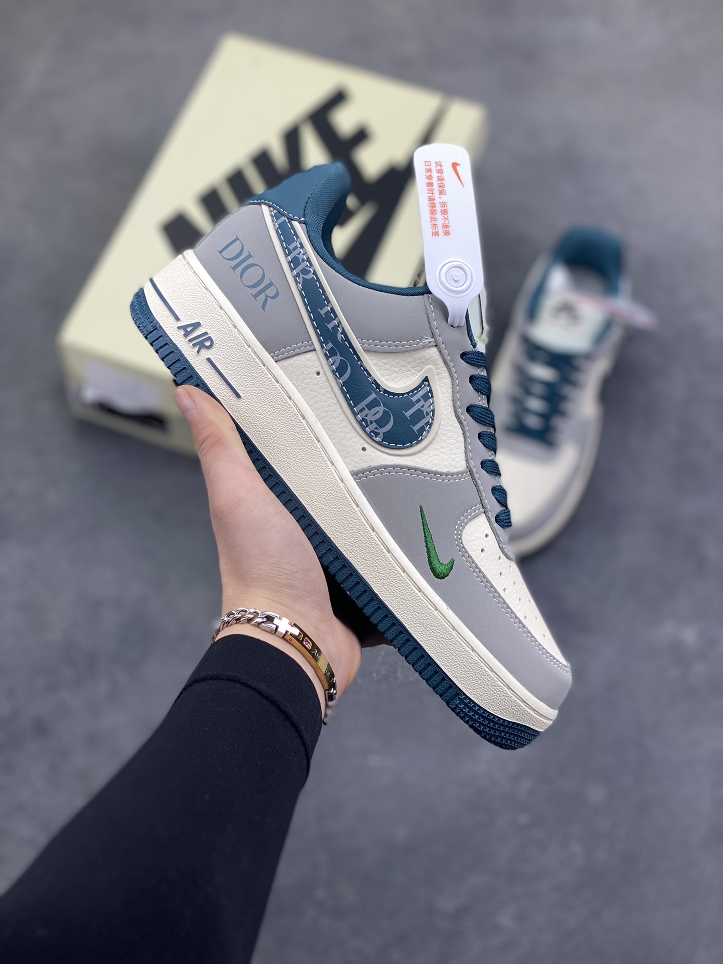 格调碰撞，经典新生！当Nike Air Force 1的街头基因遇上Dior的高奢美学，这双Air Force 1 Low DD1928-313完成了一次惊艳的风格跨界。高级灰调为主的鞋身，搭配深海蓝的撞色点缀，皮质拼接的质感扑面而来。Swoosh标志上的Dior字母印花、鞋侧的品牌标识，将奢华细节融入经典鞋型，小勾设计更是暗藏巧思。米白中底搭配蓝调外底，延续AF1的复古轮廓，又赋予了全新的视觉层次。无论是日常出街的随性搭配，还是打造高街奢潮造型，这双鞋都能成为造型的点睛之笔，让经典鞋款在奢潮融合中焕发全新魅力。-选品中心