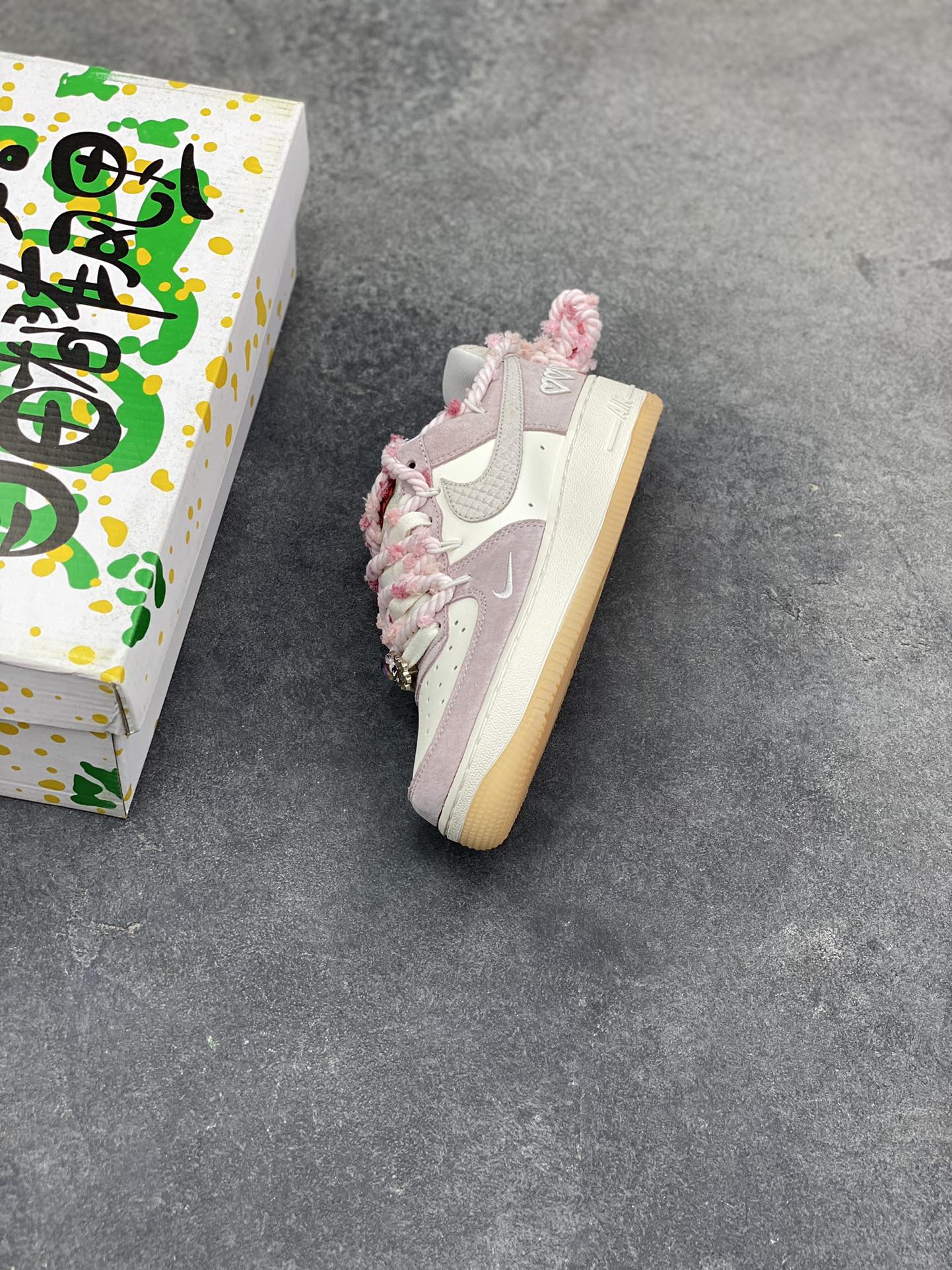 图片[7]-“芋泥告白”订制空军一号板鞋 该定制版球鞋选用原鞋款为Nike Air Force 1‘07空军一号，鞋面选用芋泥粉麂皮与米白皮革拼接，材质对比营造出细腻的质感，芋泥粉＋米白的低饱和配色搭配生胶底，复古感拉满。鞋侧后跟有镂空爱心刺绣，鞋带换成粉灰混色粗织绳带并搭配金属扣，鞋头还点缀了迷你Swoosh，爱心元素的融入让整体设计更具少女感与独特性。 货号：FA5066-111-选品中心