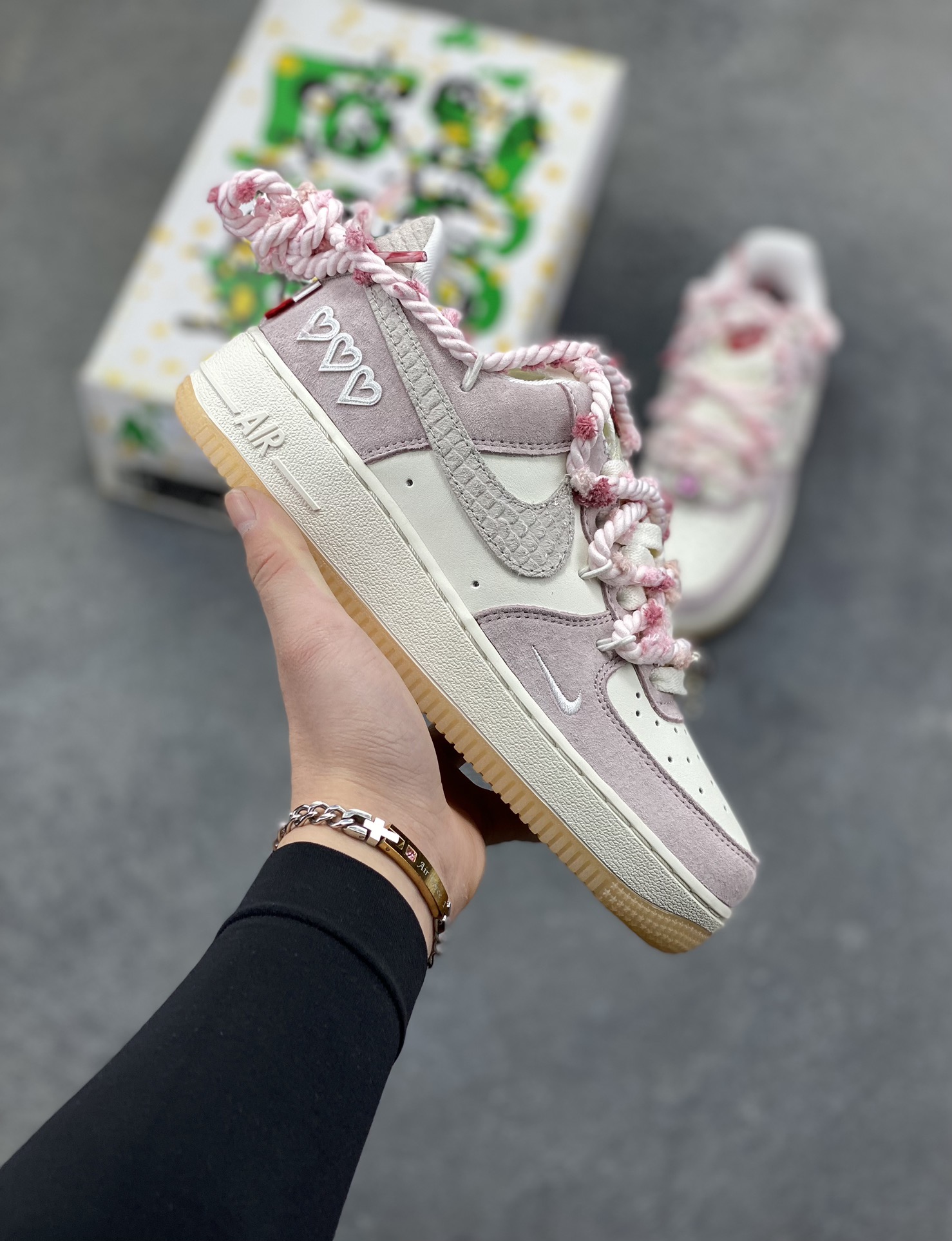 “芋泥告白”订制空军一号板鞋 该定制版球鞋选用原鞋款为Nike Air Force 1‘07空军一号，鞋面选用芋泥粉麂皮与米白皮革拼接，材质对比营造出细腻的质感，芋泥粉＋米白的低饱和配色搭配生胶底，复古感拉满。鞋侧后跟有镂空爱心刺绣，鞋带换成粉灰混色粗织绳带并搭配金属扣，鞋头还点缀了迷你Swoosh，爱心元素的融入让整体设计更具少女感与独特性。 货号：FA5066-111-选品中心