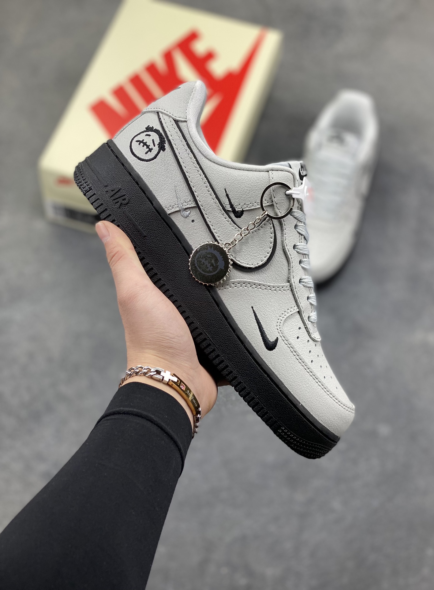 冷调灰调碰撞酷黑，Nike Air Force 1 Low 这双XL1979-128直接把街头腔调拉满！双勾设计打破经典框架，搭配搞怪卡通挂饰与刺绣细节，每一处都藏着不被定义的个性。皮革鞋面质感在线，Air气垫底延续舒适脚感，不管是搭配工装裤还是休闲裙，都能轻松成为造型焦点，属于鞋柜里不可错过的小众腔调款～-选品中心
