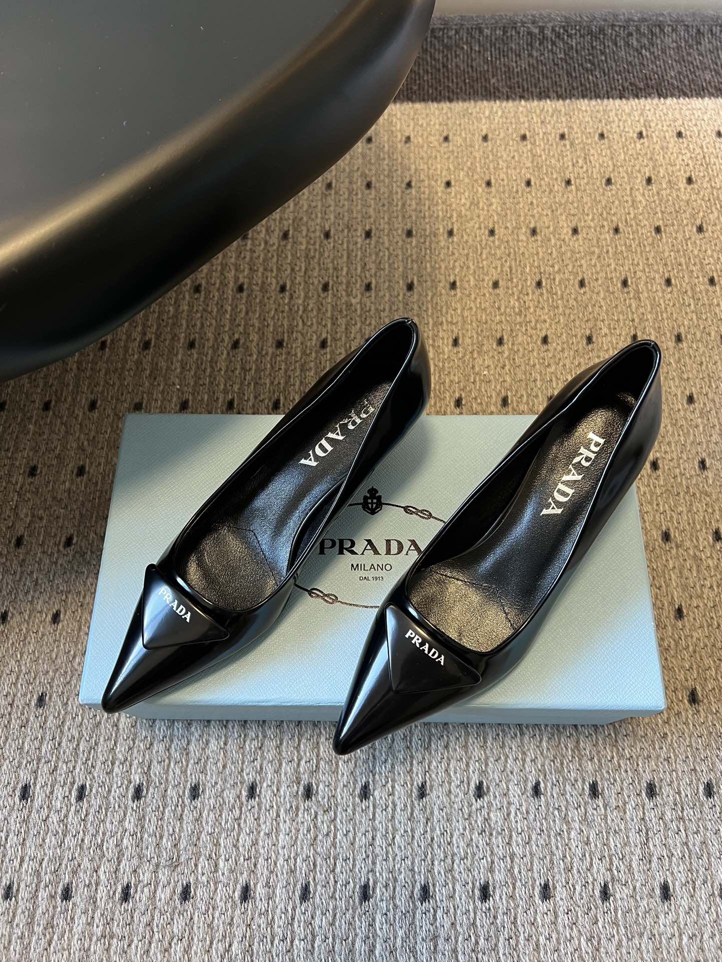 Prad* 26ss经典款三角标尖头小高跟单鞋采用锐利尖头+几何三角标的组合，鞋头处的三角拼接是品牌辨识