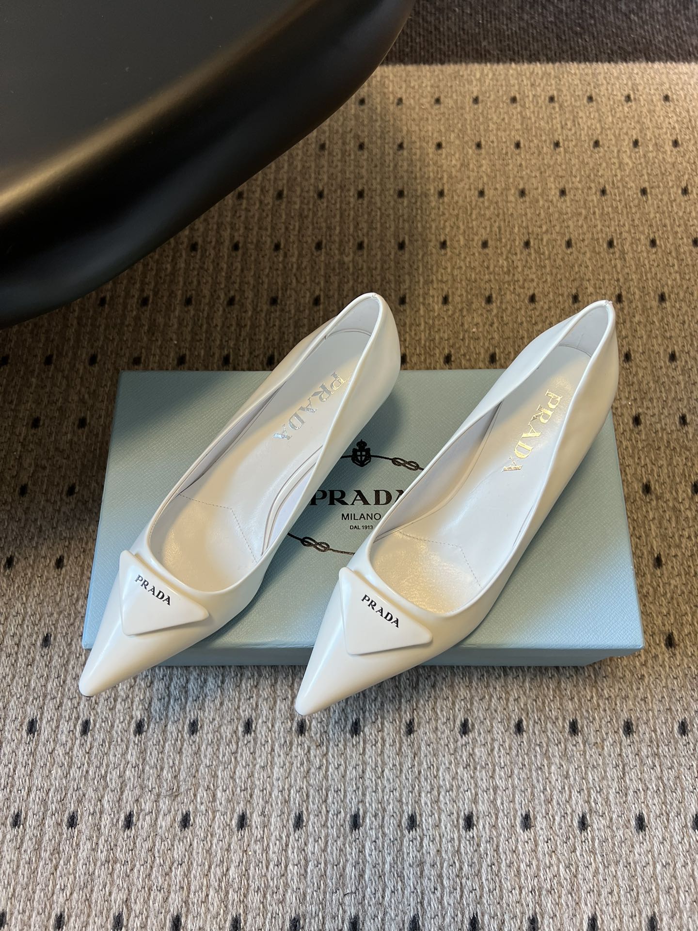Prad* 26ss经典款三角标尖头小高跟单鞋采用锐利尖头+几何三角标的组合，鞋头处的三角拼接是品牌辨识