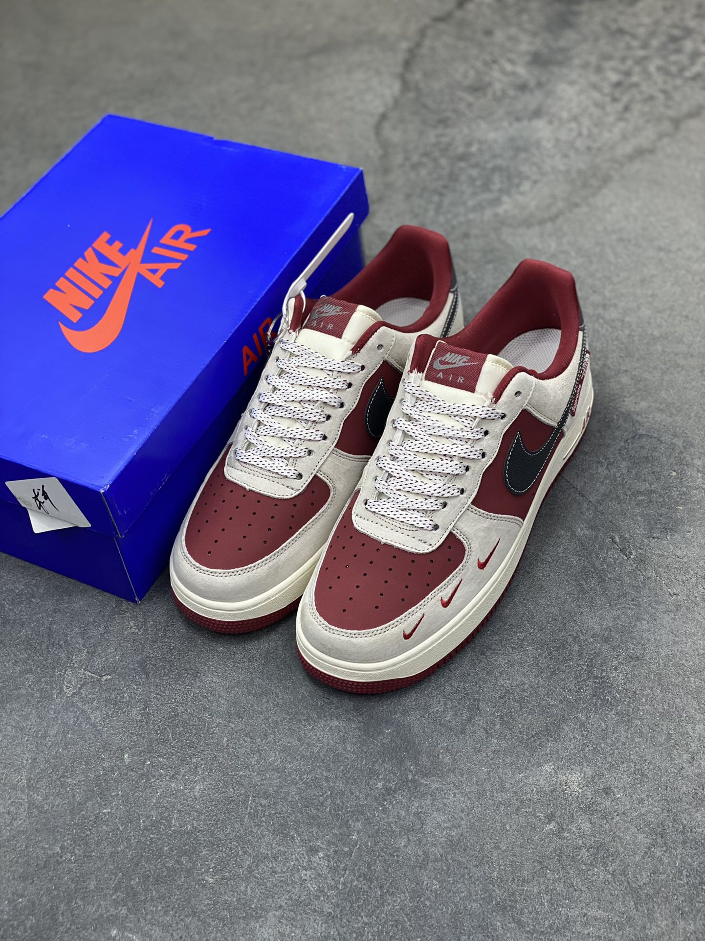 图片[8]-Nike Air Force 1 Low x Supreme x The North Face 三方联名酒红灰配色，直接把街头潮流与户外机能风焊死在鞋面上！酒红麂皮碰撞浅灰磨砂质感，鞋身多道迷你红勾打破常规，侧边Supreme×TNF织标强强联手，藏青Swoosh做旧处理更添复古韵味。白红中底刻字“Air”细节拉满，酒红外底踩出吸睛步调，挂饰吊坠更是把联名仪式感拉满。经典AF1鞋型加持，不管是搭配工装裤还是牛仔潮搭，都能轻松拿捏高阶街头感，这双SY1388-014绝对是潮人鞋柜里的收藏级狠货！-选品中心