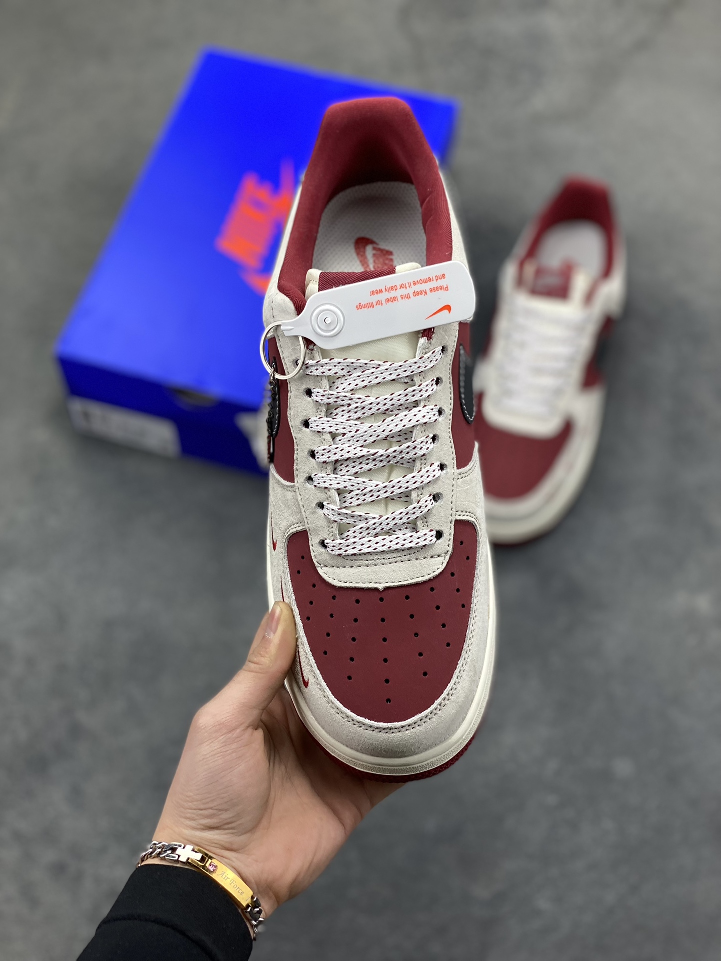 图片[2]-Nike Air Force 1 Low x Supreme x The North Face 三方联名酒红灰配色，直接把街头潮流与户外机能风焊死在鞋面上！酒红麂皮碰撞浅灰磨砂质感，鞋身多道迷你红勾打破常规，侧边Supreme×TNF织标强强联手，藏青Swoosh做旧处理更添复古韵味。白红中底刻字“Air”细节拉满，酒红外底踩出吸睛步调，挂饰吊坠更是把联名仪式感拉满。经典AF1鞋型加持，不管是搭配工装裤还是牛仔潮搭，都能轻松拿捏高阶街头感，这双SY1388-014绝对是潮人鞋柜里的收藏级狠货！-选品中心