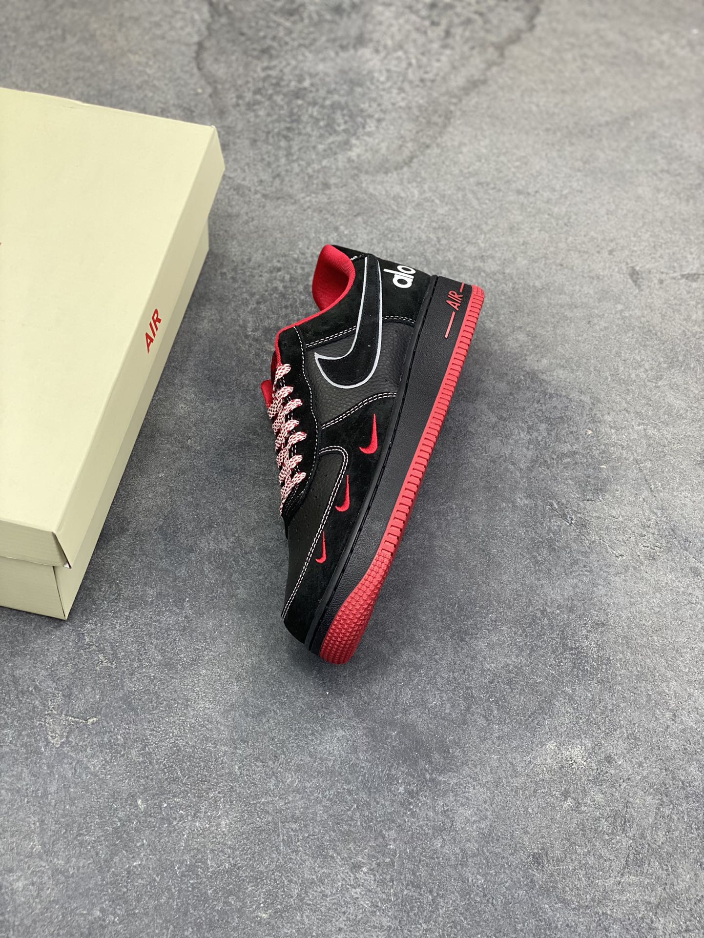 图片[7]-黑红格调，经典焕新｜Nike Air Force 1 Low alo联名款 当经典的Air Force 1 Low遇上alo的潮流基因，黑红撞色瞬间点燃街头气场。 全黑荔枝纹皮革鞋身质感拉满，鞋头点缀的红色迷你Swoosh暗藏巧思，鞋侧银线勾边的大勾在低调中透出锋芒，后跟的“alo”标识更是联名身份的亮眼注脚。红色鞋舌、鞋领包边与外底纹路形成视觉呼应，搭配红白编织鞋带，细节处尽显设计巧思。 Air气垫加持的经典中底，刻有红色“AIR”字样，延续AF1的舒适脚感与街头底蕴。黑红配色永不过时，无论是日常穿搭还是街头炸街，这双SS1979-009都能让你轻松拿捏潮流腔调，成为足下焦点。-选品中心