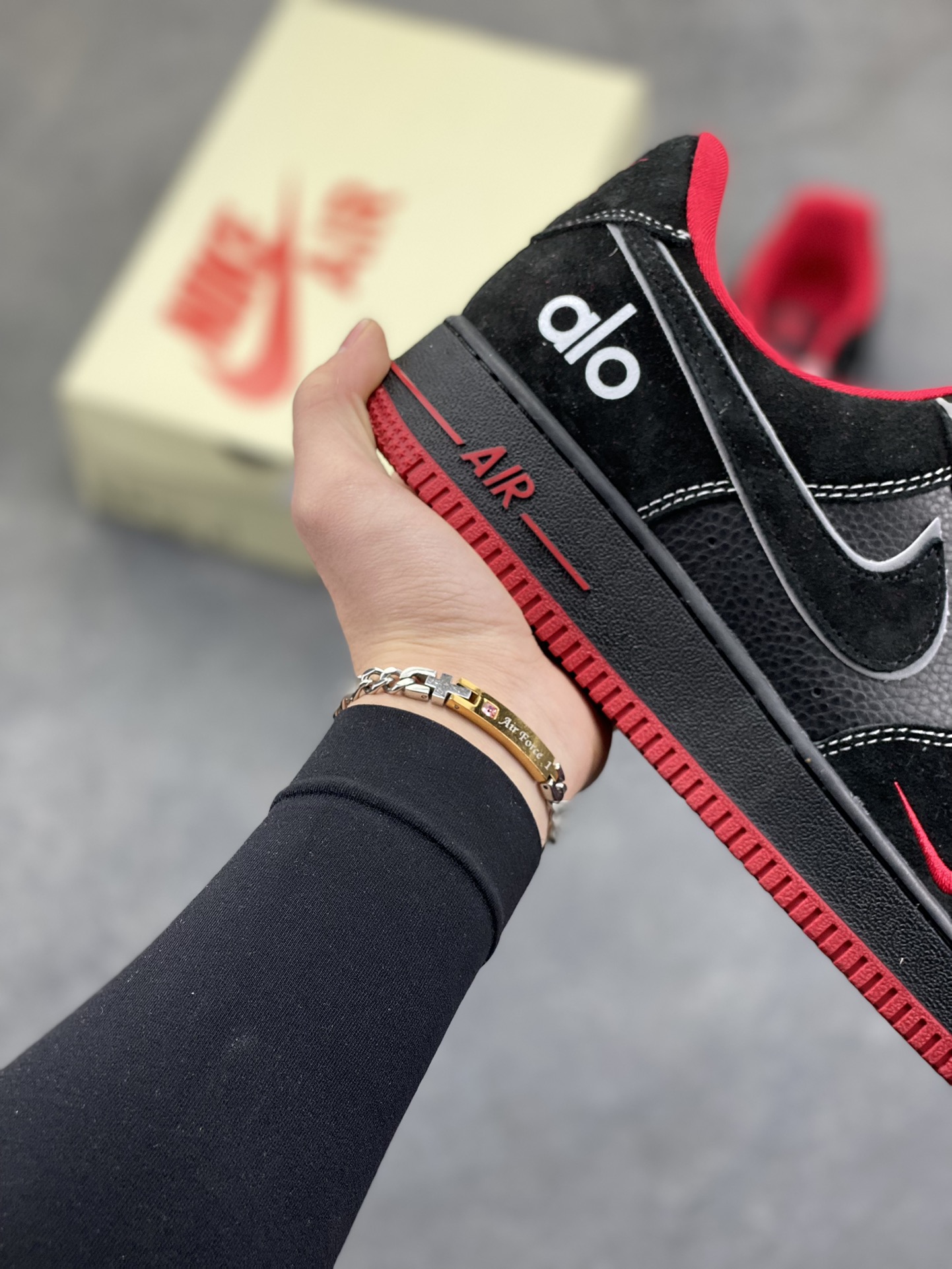 图片[6]-黑红格调，经典焕新｜Nike Air Force 1 Low alo联名款 当经典的Air Force 1 Low遇上alo的潮流基因，黑红撞色瞬间点燃街头气场。 全黑荔枝纹皮革鞋身质感拉满，鞋头点缀的红色迷你Swoosh暗藏巧思，鞋侧银线勾边的大勾在低调中透出锋芒，后跟的“alo”标识更是联名身份的亮眼注脚。红色鞋舌、鞋领包边与外底纹路形成视觉呼应，搭配红白编织鞋带，细节处尽显设计巧思。 Air气垫加持的经典中底，刻有红色“AIR”字样，延续AF1的舒适脚感与街头底蕴。黑红配色永不过时，无论是日常穿搭还是街头炸街，这双SS1979-009都能让你轻松拿捏潮流腔调，成为足下焦点。-选品中心