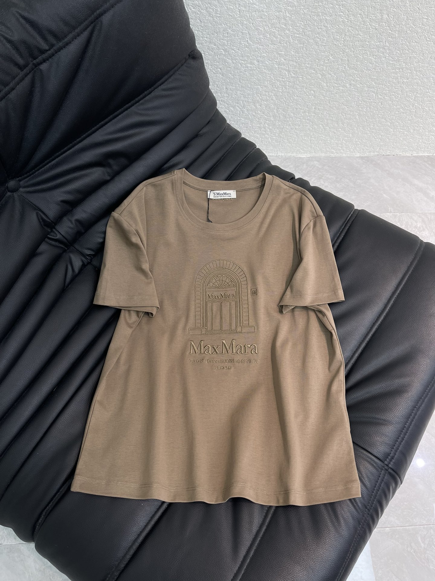 NO:687248,Maxmar*26 new spring and summer round neck embroidered logo short-sleeved T-shirt. Customized YB native cotton material, breathable and comfortable, full of texture, regular flower bud short-sleeved shirt cut, coffee color to get the Italian simple aesthetics just right!  The soft milk tea brown tone is gentle and high-end. The architectural embossed print on the chest hides retro ingenuity. The soft and waxy cotton fabric is skin-friendly and comfortable. The slightly loose version is not flattering on the body shape. Wear it alone for a casual and lazy feeling. Pair it with a suit or cardigan to unlock the sophisticated style of commuting. It is a versatile wardrobe.  The sleeves are pleated to form puff sleeves, processed with embroidery technology, and the arch embroidered letter logo decoration is outlined on the chest to enhance brand recognition and make daily wear relaxed and fashionable. SML,, T-shirt, tees, t-shirt, business  suit,19860909Maxmar*26春夏新款圆领刺绣徽标短袖T恤.定制YB原生全棉材质,透气舒适,质感十足,常规花苞短袖恤剪裁,咖色把意式简约美学拿捏得恰到好处！柔和的奶茶棕调温柔又高级,胸前的建筑浮雕印花藏着复古巧思,软糯的棉质面料亲肤又舒适,微宽松版型不挑身形,单穿是随性慵懒感,搭西装或开衫又能解锁通勤精致风,妥妥的衣柜百搭王,袖子褶皱形成泡泡袖,利用刺绣工艺处理,胸前勾勒出拱门刺绣字母徽标装饰,加强品牌辨识度,日常穿搭松弛时髦.SML,,T-shirt,tees，t-shirt,business suit,,Women's clothing