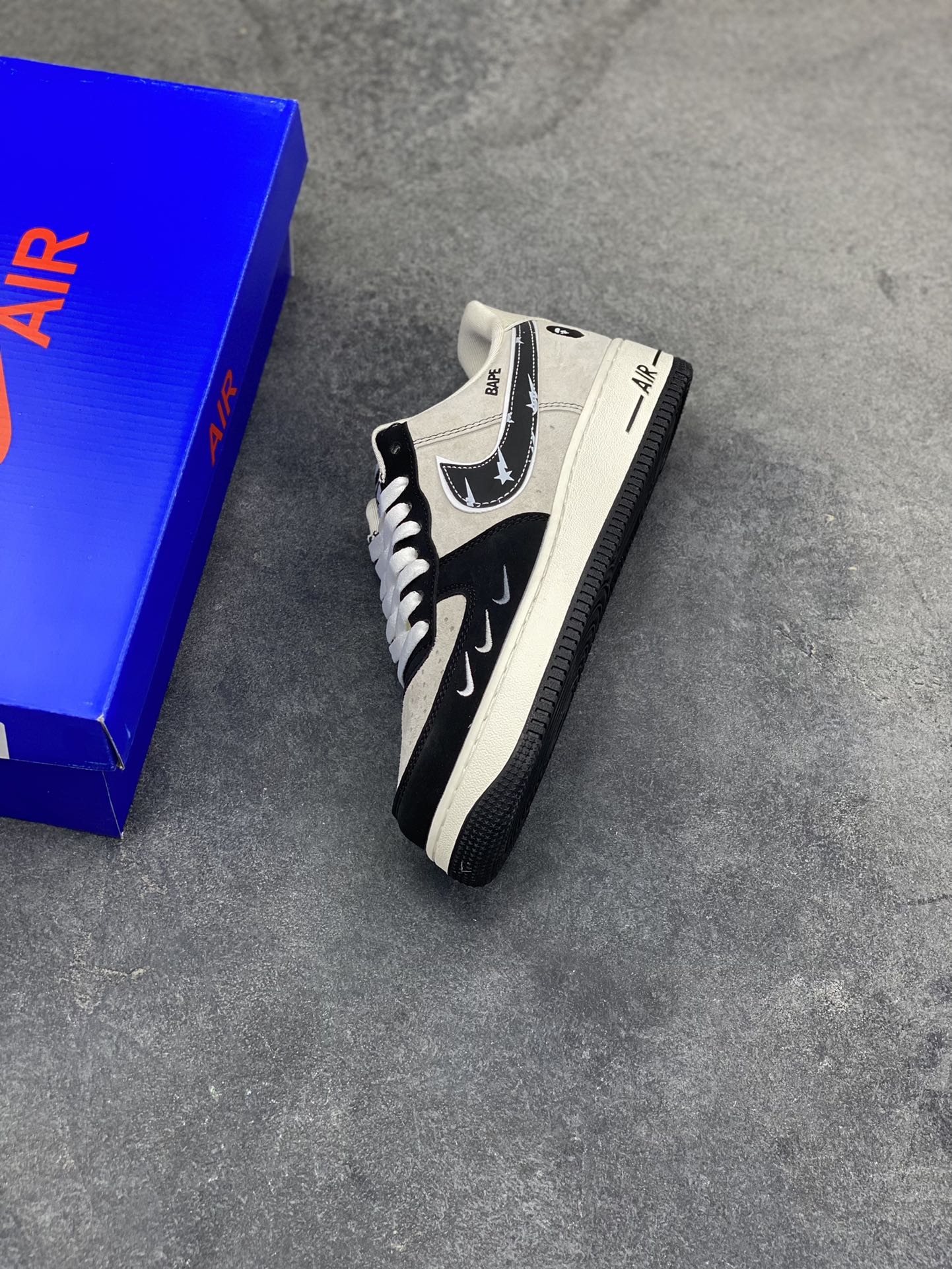 图片[7]-猿颜潮范，经典重构｜Nike Air Force 1 Low x BAPE联名款，当Nike Air Force 1 Low的传奇鞋型邂逅BAPE的街头猿力，这双SY1388-024直接将潮流辨识度拉满，米白磨砂皮革与黑色亮面材质拼接鞋身，碰撞出层次丰富的视觉质感。鞋头排布的迷你银色Swoosh打破常规，鞋侧BAPE标志性的星星闪电勾取代经典Nike标识，猿人头徽章点缀后跟，每一处细节都烙印着联名的独特基因。鞋舌处的BAPE字样与猿人头吊坠挂饰，更是将街头潮范贯彻到底，成为吸睛的点睛之笔。米白中底搭配黑色外底，经典的AF1轮廓下暗藏潮奢细节，刻字“AIR”延续鞋款的舒适内核。无论是搭配街头工装还是休闲潮搭，这双联名款都能让你轻松跳出穿搭平庸，用足下的猿颜潮范，诠释独属于你的街头态度-选品中心