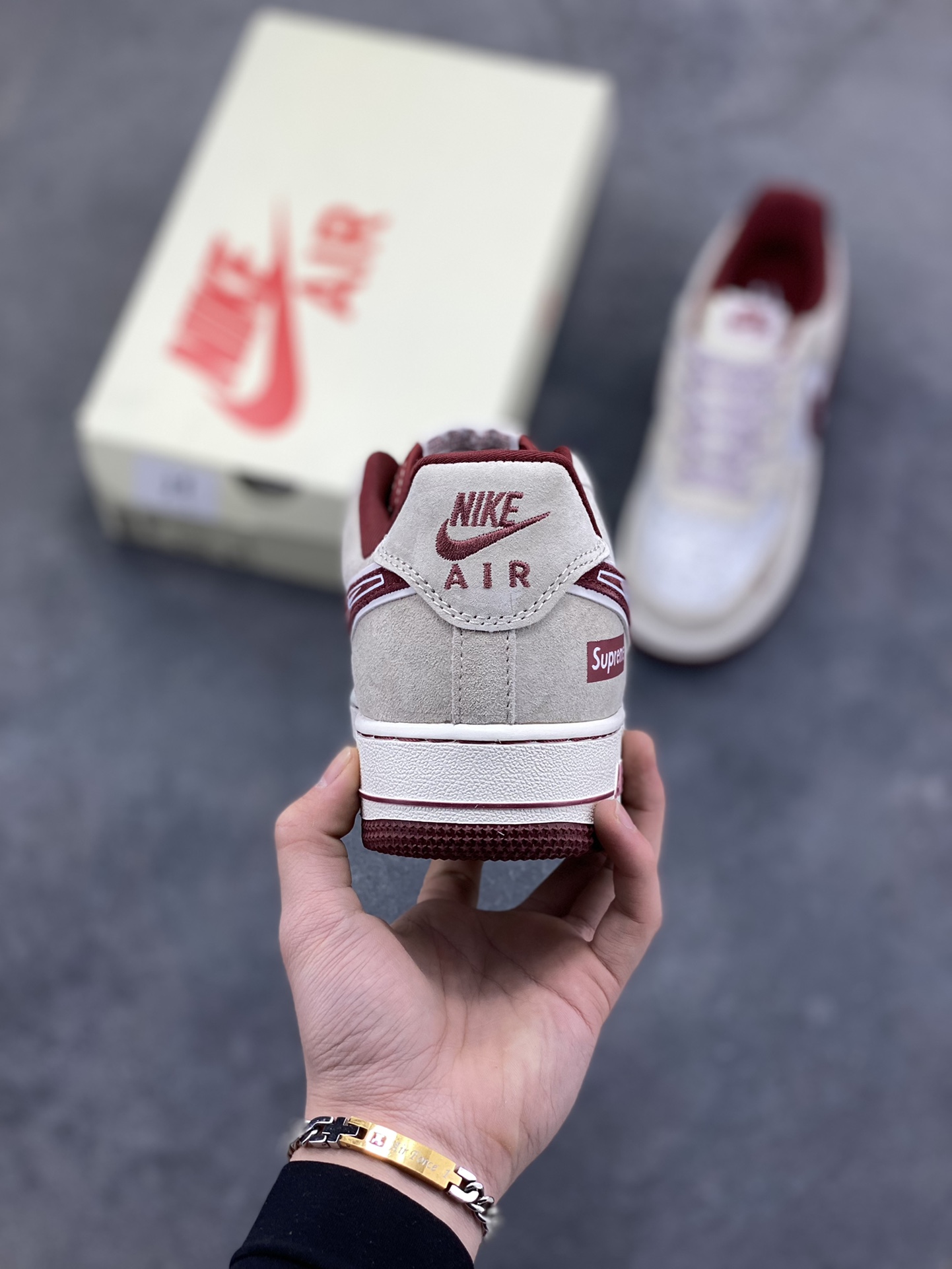 图片[4]-解构潮范，低帮新绎｜Nike Air Force 1 Low x Supreme联名款！当Nike Air Force 1 Low的经典街头底蕴碰撞Supreme的硬核潮牌基因，这双SS1979-012联名款成为街头潮流跨界的又一重磅之作，将复古板鞋的魅力与潮牌的个性表达融合到极致。 鞋身以浅米翻毛皮革为主调，酒红色饰条勾勒出利落的轮廓线条，材质的细腻质感与色彩的撞色搭配，瞬间拉满视觉层次。解构主义设计的双层Swoosh打破常规，酒红主Swoosh叠搭白色细勾，侧边印刻的“NIKE”与Supreme方块标识相互呼应，鞋舌处的编织鞋带、鞋身的涂鸦风暗纹，每一处细节都暗藏联名的巧思。鞋侧的小勾刺绣、中底的“Air”字样与酒红外底的组合，延续了Air Force 1 Low的经典轮廓，又为鞋款注入了Supreme标志性的潮酷灵魂。浅米中底搭配酒红外底，兼顾了复古脚感与潮流视觉，让这双联名款既能适配街头工装风穿搭，也能融入高街休闲造型。无论是潮牌爱好者的收藏清单，还是日常出街的吸睛选择，这双Nike Air Force 1 Low x Supreme都能以解构潮范的独特气质，让你轻松成为街头焦点。-选品中心