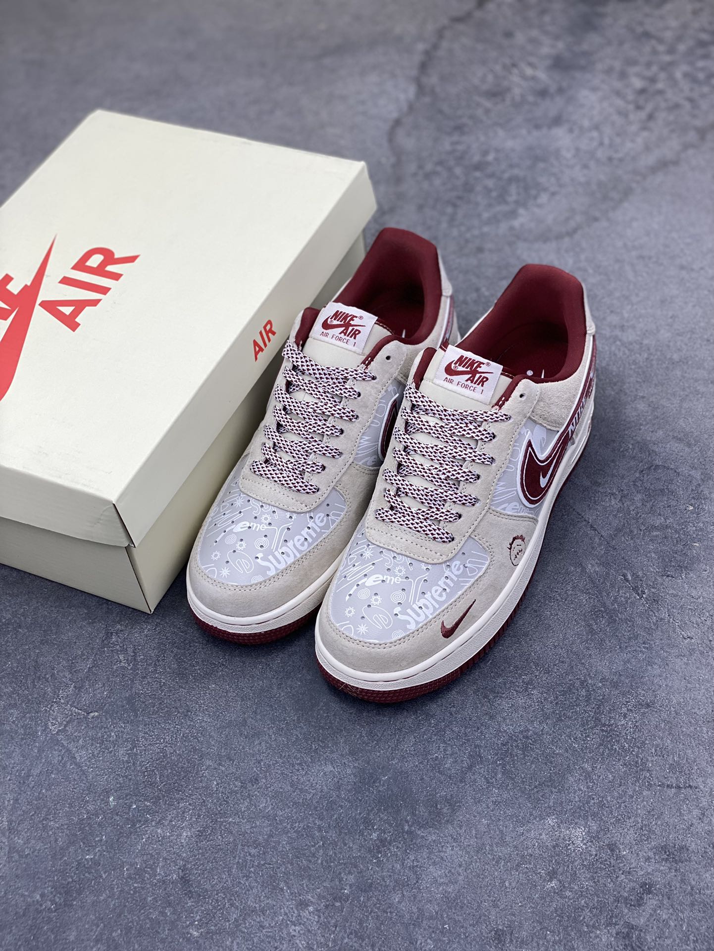 图片[8]-解构潮范，低帮新绎｜Nike Air Force 1 Low x Supreme联名款！当Nike Air Force 1 Low的经典街头底蕴碰撞Supreme的硬核潮牌基因，这双SS1979-012联名款成为街头潮流跨界的又一重磅之作，将复古板鞋的魅力与潮牌的个性表达融合到极致。 鞋身以浅米翻毛皮革为主调，酒红色饰条勾勒出利落的轮廓线条，材质的细腻质感与色彩的撞色搭配，瞬间拉满视觉层次。解构主义设计的双层Swoosh打破常规，酒红主Swoosh叠搭白色细勾，侧边印刻的“NIKE”与Supreme方块标识相互呼应，鞋舌处的编织鞋带、鞋身的涂鸦风暗纹，每一处细节都暗藏联名的巧思。鞋侧的小勾刺绣、中底的“Air”字样与酒红外底的组合，延续了Air Force 1 Low的经典轮廓，又为鞋款注入了Supreme标志性的潮酷灵魂。浅米中底搭配酒红外底，兼顾了复古脚感与潮流视觉，让这双联名款既能适配街头工装风穿搭，也能融入高街休闲造型。无论是潮牌爱好者的收藏清单，还是日常出街的吸睛选择，这双Nike Air Force 1 Low x Supreme都能以解构潮范的独特气质，让你轻松成为街头焦点。-选品中心