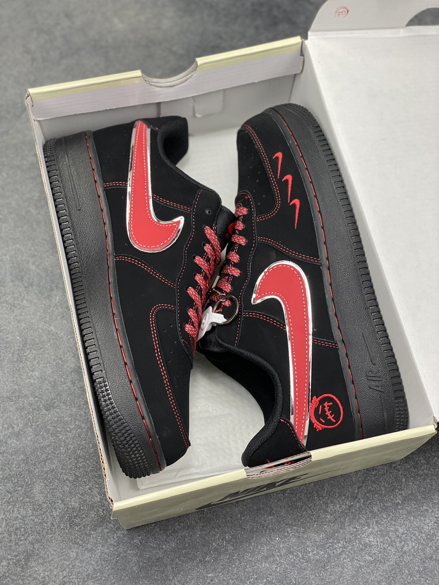图片[9]-黑红锋芒｜Nike Air Force 1 Low 暗黑红刃款炸街来袭！经典空军一号再出王炸款！这双DD1982-339以黑红为主调，将暗黑酷感与炽热锋芒完美融合，直接刷新街头潮流新高度。鞋身通体采用哑光黑麂皮打造，质感高级又自带低调的酷感，鞋侧的Swoosh以红银撞色呈现，金属质感的轮廓搭配鲜红内里，宛如利刃出鞘般极具视觉冲击力；鞋头处的迷你红色小勾、鞋身的红色刺绣标识，再加上鞋帮处的专属徽章图案，每一处细节都暗藏巧思，让整双鞋的设计感拉满。Air Force 1的经典气垫中底延续了舒适脚感，黑红配色的中底与鞋身呼应，整体造型利落又张扬。不管是搭配黑色系工装裤打造暗黑街头风，还是配破洞牛仔玩转出彩混搭，这双鞋都能成为造型的灵魂亮点，轻松拿捏街头吸睛密码。作为空军一号的个性定制款，它不仅是脚下的穿搭利器，更是潮流玩家表达自我风格的绝佳载体，上脚即解锁独树一帜的潮流态-选品中心