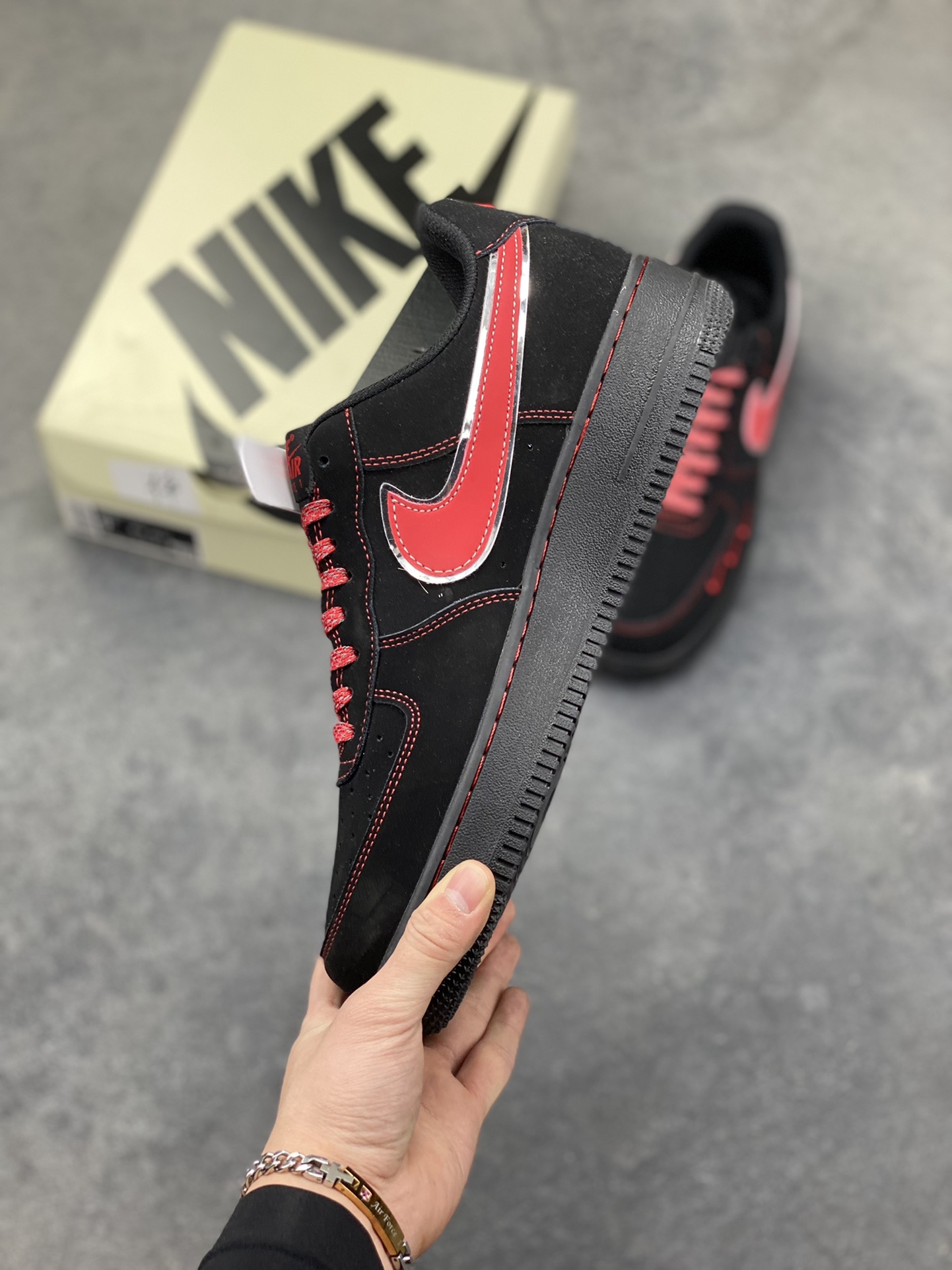 图片[3]-黑红锋芒｜Nike Air Force 1 Low 暗黑红刃款炸街来袭！经典空军一号再出王炸款！这双DD1982-339以黑红为主调，将暗黑酷感与炽热锋芒完美融合，直接刷新街头潮流新高度。鞋身通体采用哑光黑麂皮打造，质感高级又自带低调的酷感，鞋侧的Swoosh以红银撞色呈现，金属质感的轮廓搭配鲜红内里，宛如利刃出鞘般极具视觉冲击力；鞋头处的迷你红色小勾、鞋身的红色刺绣标识，再加上鞋帮处的专属徽章图案，每一处细节都暗藏巧思，让整双鞋的设计感拉满。Air Force 1的经典气垫中底延续了舒适脚感，黑红配色的中底与鞋身呼应，整体造型利落又张扬。不管是搭配黑色系工装裤打造暗黑街头风，还是配破洞牛仔玩转出彩混搭，这双鞋都能成为造型的灵魂亮点，轻松拿捏街头吸睛密码。作为空军一号的个性定制款，它不仅是脚下的穿搭利器，更是潮流玩家表达自我风格的绝佳载体，上脚即解锁独树一帜的潮流态-选品中心