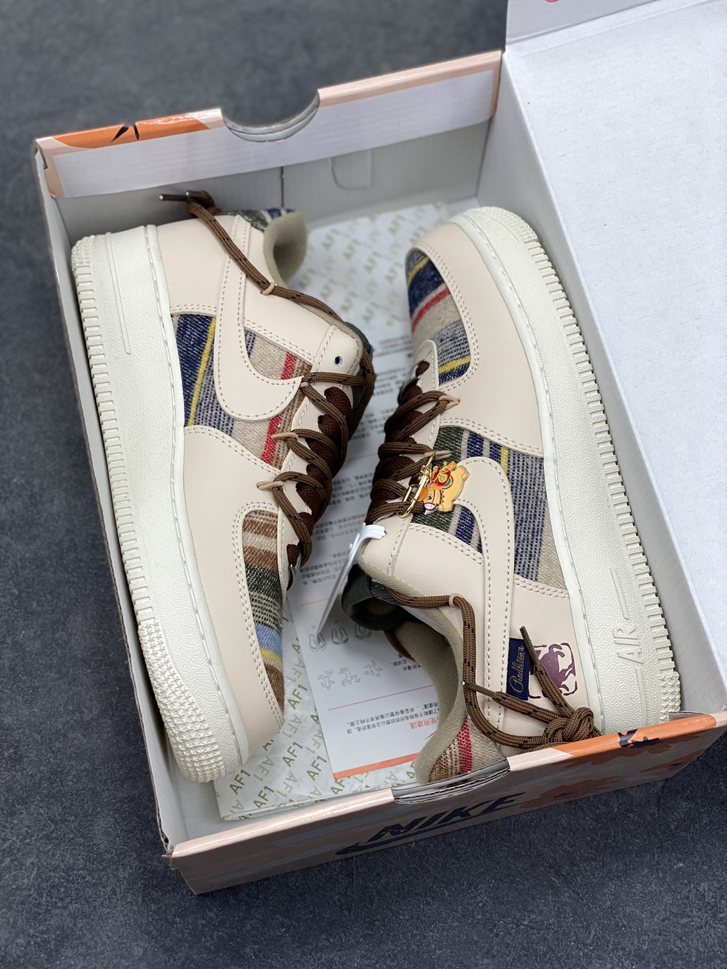 图片[9]-“焦糖小马”订制空军一号板鞋 该定制版球鞋选用原鞋款为Nike Air Force 1‘07空军一号，主体采用米杏色，搭配格纹布料拼接，鞋侧Swoosh也融入了格纹与纯色皮革的组合，营造出复古的美拉德色系风格。鞋带为棕色粗绳设计，配有卡通挂饰；鞋后跟处有马术风格的图案刺绣，增添了个性化元素。 货号：CW1186-230 尺码： 39 40 40.5 41 42 42.5 43 44 44.5 45-选品中心