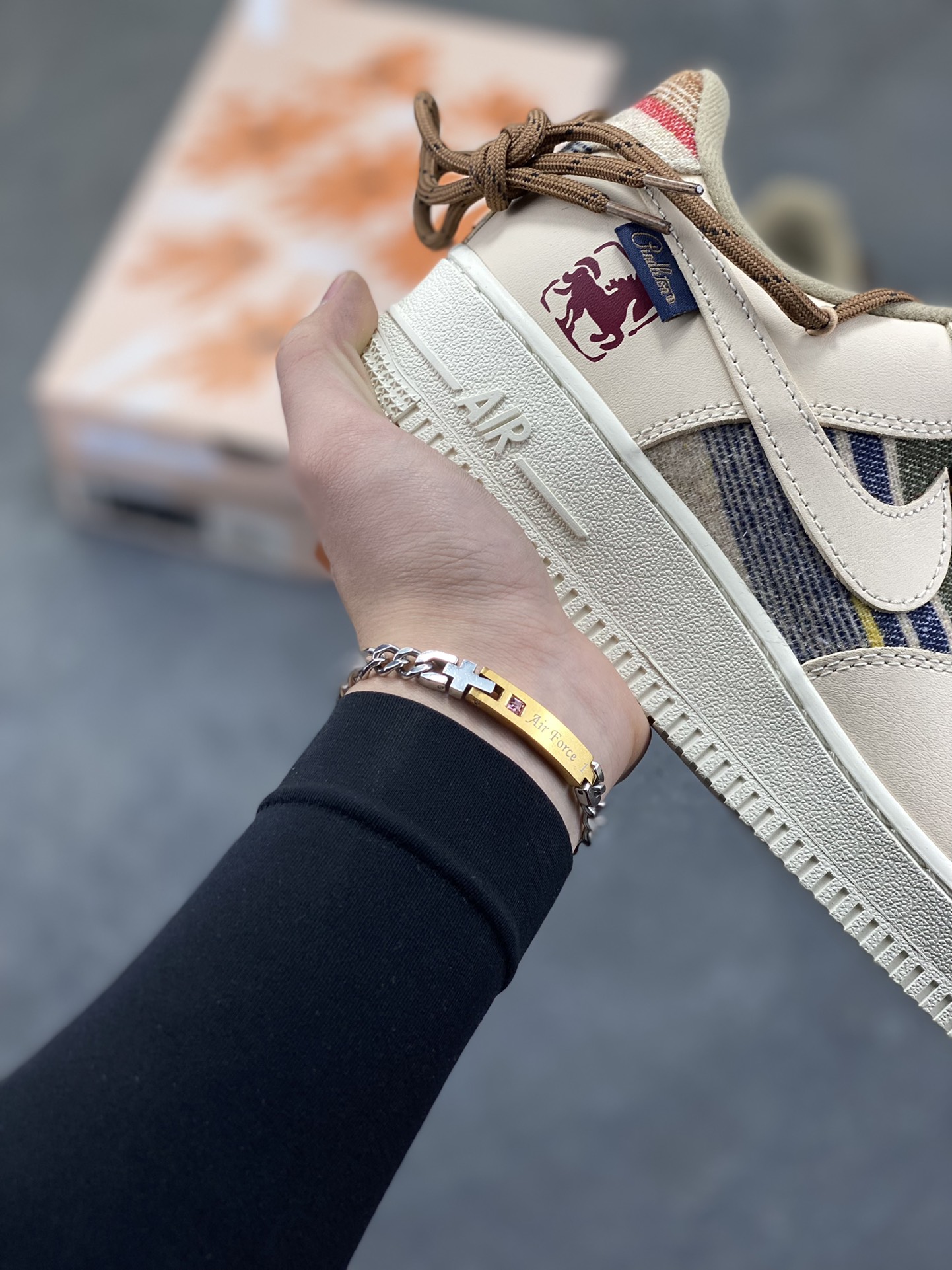 图片[6]-“焦糖小马”订制空军一号板鞋 该定制版球鞋选用原鞋款为Nike Air Force 1‘07空军一号，主体采用米杏色，搭配格纹布料拼接，鞋侧Swoosh也融入了格纹与纯色皮革的组合，营造出复古的美拉德色系风格。鞋带为棕色粗绳设计，配有卡通挂饰；鞋后跟处有马术风格的图案刺绣，增添了个性化元素。 货号：CW1186-230 尺码： 39 40 40.5 41 42 42.5 43 44 44.5 45-选品中心