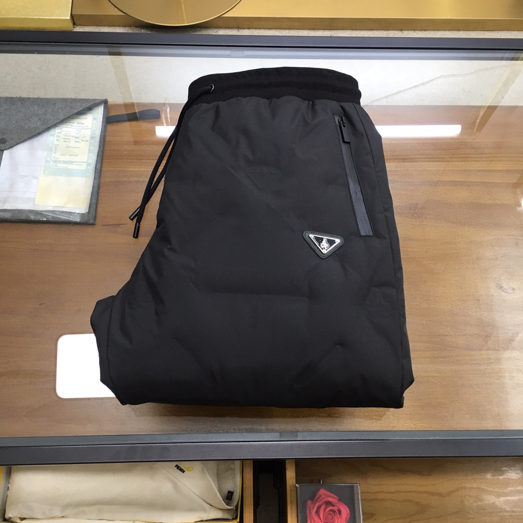 NO:690544,Down pants [Prad] 25 autumn and winter new classic down pants, each part is evenly filled with down, including 90% duck down. High-end brand element logo technology D is lined with double-layer high-density fabrics that will not run away at all, and there will be no pile of down. L is light and warm, the upper body is not bloated, and can modify the shape of the legs. Color is black, size M-3XL, prada, down jacket,19860909羽绒裤【Prad】 25秋冬新款经典羽绒裤,每一处平均充绒,含90鸭绒.高档品牌元素logo工艺D内衬双层高密度面料完全不跑毛,也不会有堆绒现象,L轻盈又保暖,上身不臃肿,又能修饰腿型.颜色黑色,码数M-3XL,,prada,down jacket,,Men's clothing