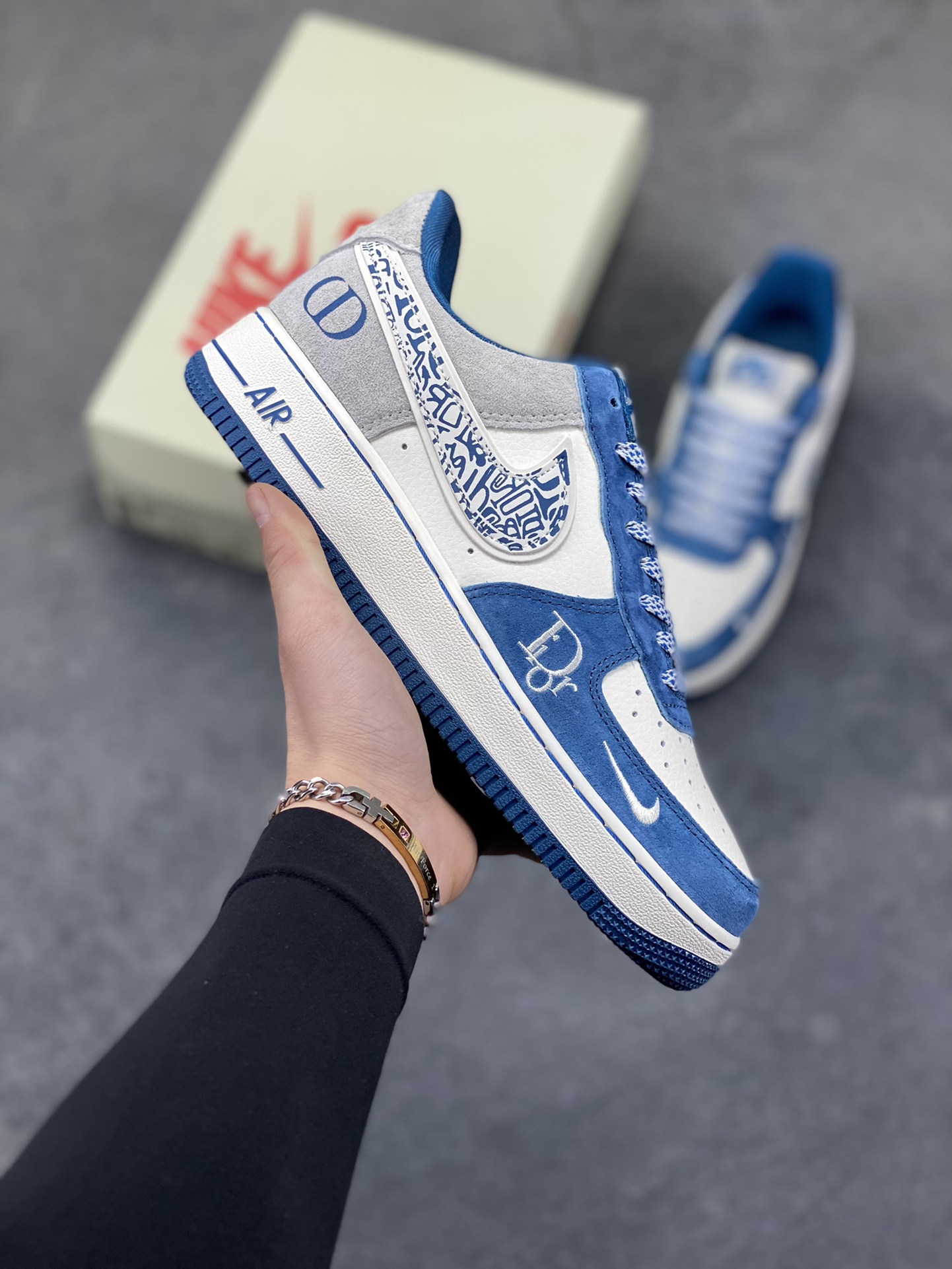 奢潮碰撞，经典重塑｜Nike Air Force 1 Low x Dior联名定制款！当高奢顶流Dior遇上街头经典Nike Air Force 1 Low，这双SS1979-010直接将奢潮融合的美学玩到了极致！鞋身以雾霾蓝翻毛皮搭配米白荔枝纹皮革，拼接浅灰麂皮打造出层次丰富的视觉质感；Dior经典的Oblique老花铺满Swoosh，鞋侧的CD字母标识与鞋头迷你勾刺绣遥相呼应，奢牌基因与街头符号的碰撞毫无违和感。经典的AIR气垫大底保留了AF1的复古灵魂，上脚既能踩出舒适脚感，又能轻松拿捏高街与奢雅的双重风格。不管是搭配高街工装还是轻奢休闲装，这双定制款AF1都能成为造型的点睛之笔，让你在潮流圈层里轻松脱颖而出！-选品中心