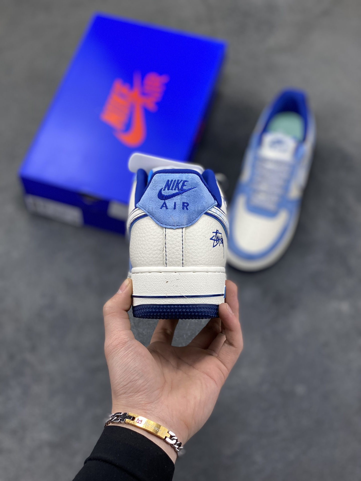 图片[4]-蓝白格调，经典焕新｜Nike Air Force 1 Low Stüssy联名款！当经典的Air Force 1 Low遇上街头潮牌Stüssy的不羁灵魂，这双SY1388-020直接把复古与潮流焊死在鞋面上！奶白皮革打底，搭配北卡蓝翻毛皮鞋头与鞋帮，撞色层次感拉满；鞋身遍布Stüssy手写签名、标志性小人logo，还有专属金属吊牌点缀，细节处全是街头态度。经典的AIR鞋底搭配Nike小勾刺绣，复古DNA刻进骨子里，上脚既适配日常穿搭，又能轻松成为造型焦点。不管是滑板街头还是城市通勤，这双蓝白配色的AF1联名款，都是你鞋柜里不可错过的潮流硬通货！-选品中心