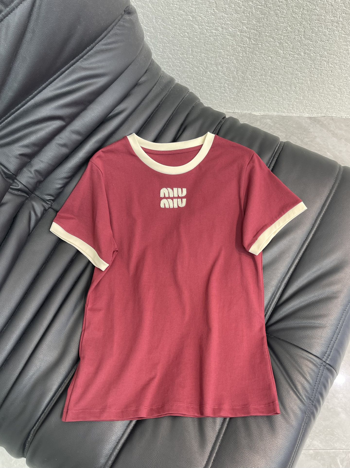 NO:695230,Miumi*26 new spring and summer contrasting color round neck cotton short-sleeved T-shirt | Exclusively developed by yb!  Top quality production!  The main color is retro burgundy, with off-white contrasting round neck and cuffs, creating a sweet element that is highly recognizable to the brand. It is made of high-quality cotton fabrics, which is soft and breathable, and has excellent skin-friendly properties. The slim cut fits the body shape without being tight and looks neat. The three-dimensional logo embroidery on the chest is exquisite, injecting a light luxury texture into the basic T-shirt. It is a versatile item for daily wear and styling in early spring. SML  AA,,miumiu,T-shirt,tees,t-shirt,19860909Miumi*26春夏新款撞色圆领棉质短袖T恤丨独家yb开发！顶级高版出品！以复古酒红为主调,搭配米白色撞色圆领与袖口,打造出极具品牌辨识度的甜美元素.精选优质棉质面料,触感柔软透气,亲肤性极佳；修身剪裁贴合身形,不紧绷更显利落.胸前立体logo刺绣工艺精致,为基础款T恤注入轻奢质感,是早春日常穿搭与造型搭配的百搭单品.SML AA,,miumiu,T-shirt,tees，t-shirt,,Women's clothing