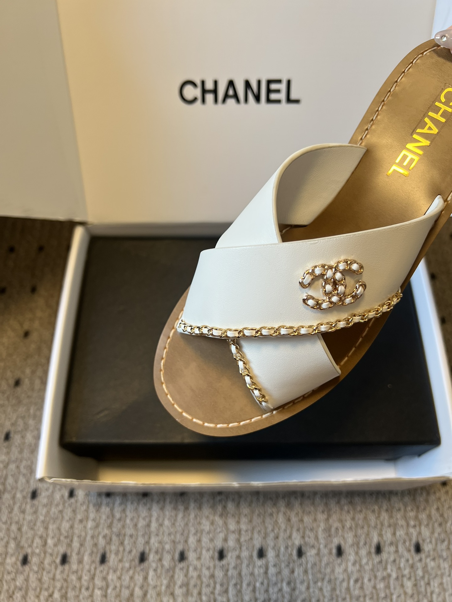 Chane*26ss 金属链条装饰交叉带平底凉拖采用交叉带凉拖版型，露趾平底的样式兼顾舒适与休闲感，无后