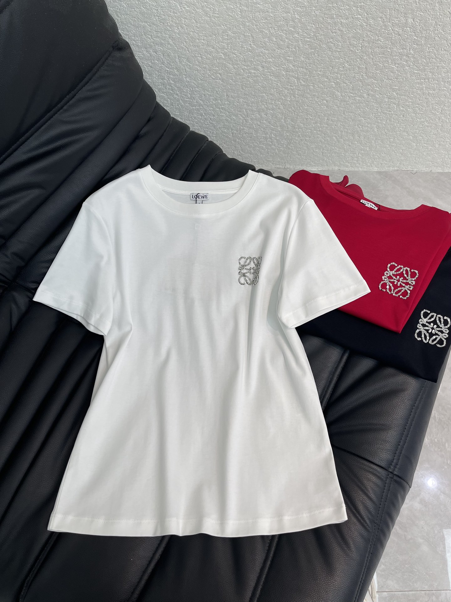 NO:696958,Loew*26 new spring and summer beaded totem logo short-sleeved T-shirt. Customized YB mercerized cotton material, breathable and comfortable, full of texture, regular short-sleeved T-shirt cut, solid color outlines a simple basic version, the chest totem logo is three-dimensionally presented with beading technology, becoming the finishing touch of the body. This T-shirt also knows how to be simple and high-end!  The totem on the chest is low-key and exquisite. The soft and waxy cotton fabric is super comfortable to wear next to the body. The classic round neck shape is not flattering on the figure. Whether worn alone or layered as an inner layer, it is a versatile and unmistakable treasure item in the wardrobe. SML A,, loewe, T-shirt, tees, t-shirt,19860909Loew*26春夏新款钉珠图腾徽标短袖T恤.定制YB丝光全棉材质,透气舒适,质感十足,常规短袖T恤裁剪,纯色勾勒出简约的基础版型,胸口图腾标识以钉珠工艺立体呈现,成为衣身的点睛之笔.这款T恤也太懂简约高级感了！胸口的图腾低调又精致,软糯的棉质面料贴身穿超舒服,经典的圆领版型不挑身材,不管是单穿还是作为内搭叠穿,都是衣橱里百搭又不出错的宝藏单品.SML A,,loewe,T-shirt,tees，t-shirt,,Women's clothing