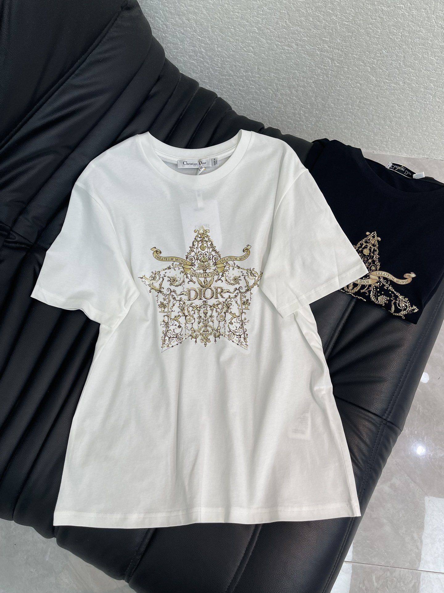 NO:697678,DIO*26 new spring and summer starburst totem hot-drilled short-sleeved T-shirt. The starburst shape on the chest is made with heavy hot-drilled + gold thread embroidery. The diamond surface is made of high-quality diamonds, which reflects the bright light and shadow. The winding Baroque pattern is intertwined with CD letters, and the details are full of high-end texture. SML A,, dior, T-shirt, tees, t-shirt,19860909DIO*26春夏新品星芒图腾烫钻短袖T恤.胸前星芒造型采用重工烫钻+金线刺绣双工艺打造,钻面选用优质钻,折射出璀璨光影；缠绕的巴洛克花纹与CD字母交织,细节处尽显高定质感.SML A,,dior,T-shirt,tees，t-shirt,,Women's clothing