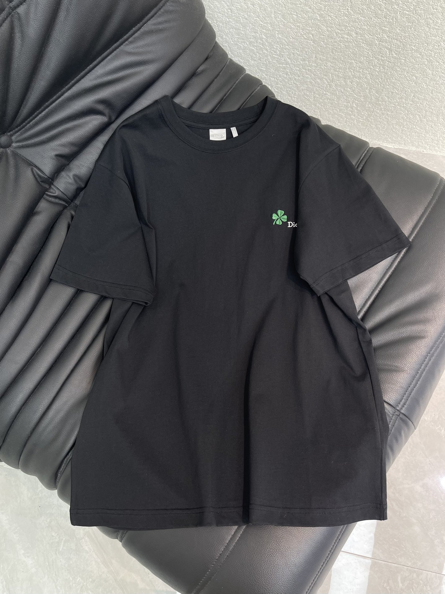NO:697308,Dio*26 new spring and summer round neck embroidered logo short-sleeved T-shirt. Customized YB native cotton material, made with machines imported from Germany, ultra-density processing, stylish texture, stretchy and comfortable, perfectly restoring YB quality, the four-leaf clover embroidered T-shirt is too detailed!  The pure black background color is low-key and versatile. The green four-leaf clover embroidery on the chest is full of lucky meanings. The delicate logo is more exquisite. The soft and waxy cotton fabric is skin-friendly and breathable. The loose version is super friendly to all body types. Whether worn alone or layered, it is a practical and stylish basic style in the wardrobe. SML AA,, dior, T-shirt, tees, t-shirt,19860909Dio*26春夏新款圆领刺绣徽标短袖T恤.定制YB原生全棉材质,德国进口机器打造,超密度处理,质感有型,弹力舒适,完美还原YB品质,四叶草刺绣T恤太戳细节控了！纯黑底色低调又百搭,胸口的绿色四叶草刺绣带着满满的幸运寓意,搭配细巧的logo更显精致,软糯的棉质面料亲肤透气,宽松版型对各种身材都超友好,不管单穿还是叠穿,都是衣橱里实穿又有格调的基础款.SML AA,,dior,T-shirt,tees，t-shirt,,Women's clothing