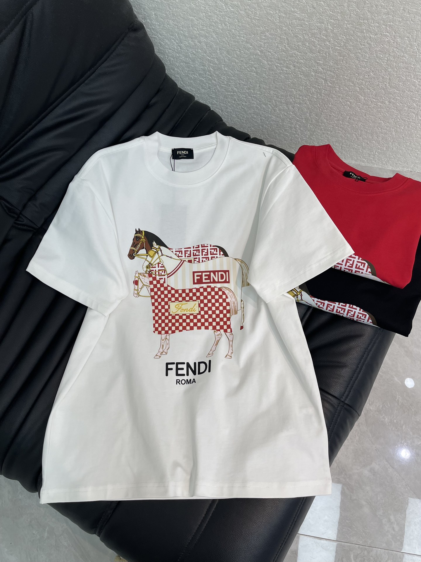NO:708178,FEND*26 new New Year's short-sleeved T-shirt FENDI New Year's limited T-shirt is so good! Horse print + plaid element, welding the 'nobleness' on the body~ Heavy cotton, crisp and not easy to deform, skin-friendly and breathable, suitable for autumn and winter alone or layered, full of high-end feeling. The horse on the front wears a red and white plaid cape, which blends  The FF classic letters and brand logo are elegant and smart. The red model has a festive atmosphere, and the black/white model is versatile for everyday use. The same style for men and women!  S-XL A,,fendi,T-shirt,tees,t-shirt,19860909FEND*26新款贺岁款短袖T恤FENDI新年限定T恤太会了!骏马印花+格纹元素,把'贵气'焊在身上~重磅纯棉,挺括不易变形,亲肤透气,秋冬单穿或内搭都合适,高级感拉满.正面骏马身披红白格纹披风,融合 FF经典字母与品牌标识,贵气又灵动,红色款自带节日氛围感,黑/白款日常百搭不挑人.男女同款！S-XL A,,fendi,T-shirt,tees，t-shirt,,Women's clothing