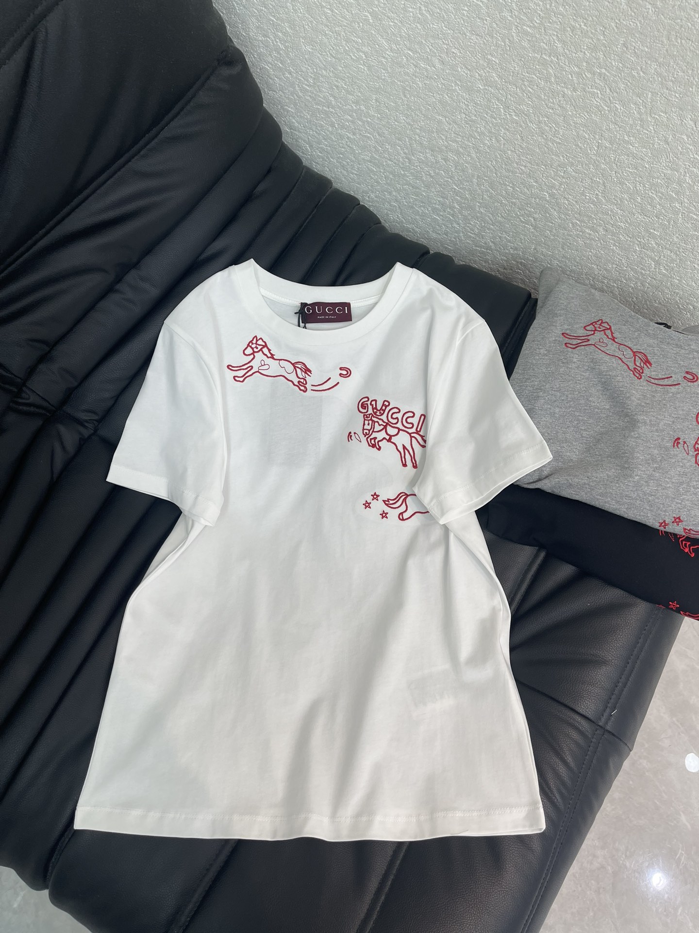 NO:708519,Gucc*26 new spring and summer new New Year embroidered Horse logo short-sleeved T-shirt. New Year Series #Customized YB mercerized cotton material, breathable and comfortable, full of texture, regular T-shirt cutting, limited to the Year of the Horse zodiac sign, so ingenious!  White, gray and black are available in three colors. The galloping horse and double G pattern outlined in embroidered red thread are smart and playful, perfectly integrating the New Year atmosphere and the brand logo. The high-density combed cotton fabric is soft and skin-friendly, and the regular basic version is not flattering on the body shape. It is refreshing and neat to wear alone, and can also unlock the sense of layering when layered with jackets. It is easy to create a light, luxurious and lively tone for daily wear. SML A,, gucci, jackets & coats, T-shirt, tees, t-shirt,19860909Gucc*26春夏新款贺岁刺绣马年徽标短袖T恤.新年贺岁系列#定制YB丝光全棉材质,透气舒适,质感十足,常规T恤裁剪,马年生肖限定太有巧思了！白灰黑三色可选,刺绣红线勾勒的奔马与双G图案灵动俏皮,把新年氛围感和品牌标识完美融合.高密精梳棉面料软弹亲肤,常规的基础版型不挑身形,单穿清爽利落,叠穿外套也能解锁层次感,日常穿搭轻松拿捏轻奢又活泼的腔调.SML A,,gucci,jackets & coats,T-shirt,tees，t-shirt,,Women's clothing