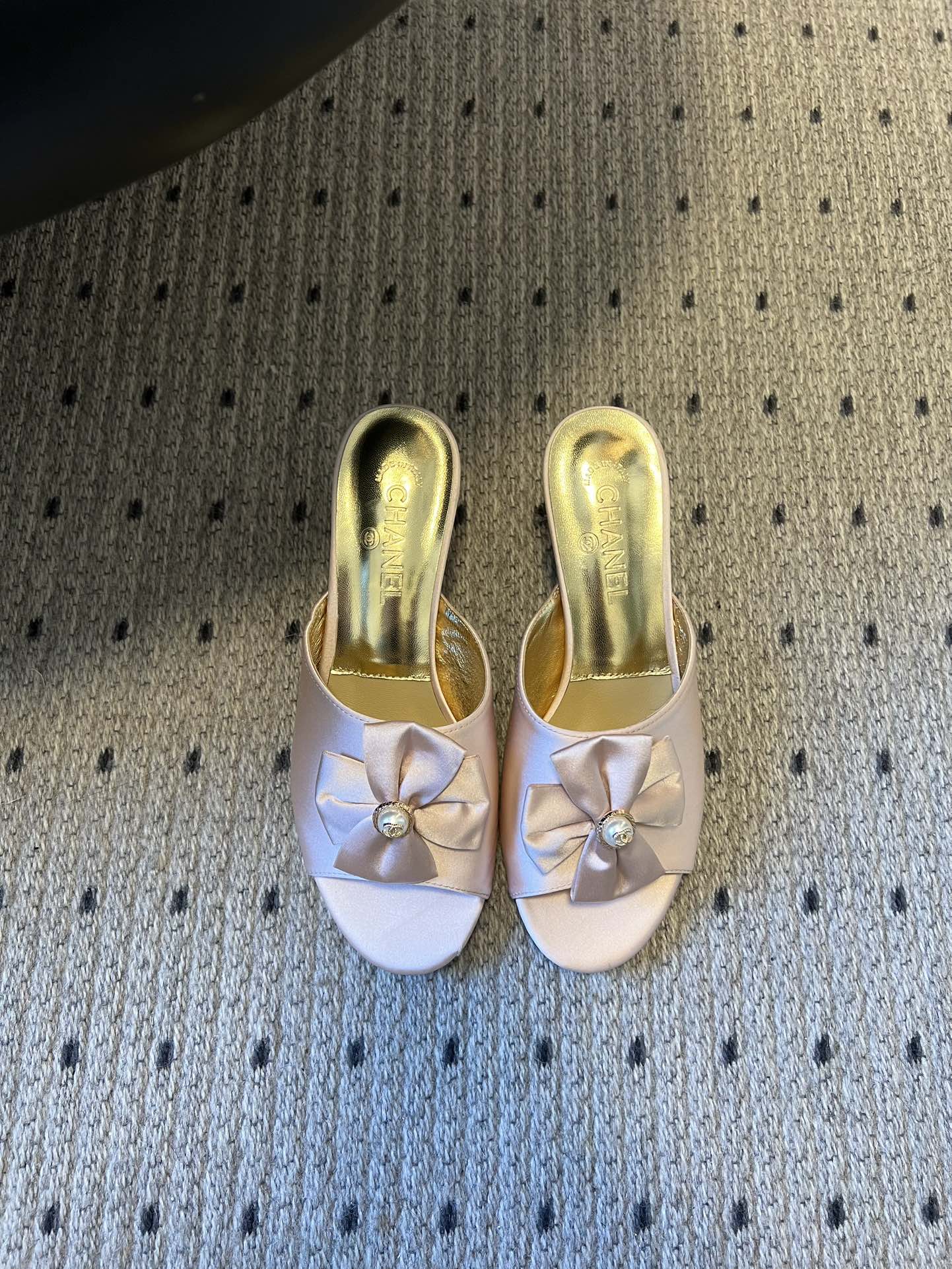 NO:706573,Chane* 26ss new spring and summer bow and pearl decorated high-heeled slippers. Each pair of toes is equipped with the brand's iconic bow + pearl decoration, which is a highly recognizable classic design language. The heelless mule shoe shape is both elegant and practical, suitable for indoor or light social occasions. The open toe is visually lighter and suitable for matching needs in spring and summer.  Contains a variety of materials such as satin, metallic leather, glitter fabrics, etc., showing different luster and texture. It covers nude pink, off-white, black gold, silver, gold and other colors, which can not only adapt to daily commuting, but also meet the matching needs of formal occasions such as dinner parties. Upper cowhide, lining sheepskin, sole leather outsole, increased by 6cm  Size 35-41 (customized sizes 40 and 41 are not returnable), slippers, chanel, slippers, cowhide, sheepskin, Leather soles19860909Chane* 26ss春夏新款蝴蝶结珍珠装饰高跟拖鞋 每双鞋头都带有品牌标志性的蝴蝶结+珍珠装饰,是辨识度极高的经典设计语言.无后跟的穆勒鞋型,兼具优雅感与实用性,适合室内或轻社交场合穿着.鞋头为开放式露趾,视觉上更显轻盈,也适配春夏季节的搭配需求. 包含缎面、金属感皮革、闪粉面料等多种材质,呈现出不同的光泽与质感.涵盖了裸粉、米白、黑金、银、金等配色,既能适配日常通勤,也能满足晚宴等正式场合的搭配需求. 鞋面牛皮 内里羊皮 鞋底真皮大底 增高6cm Size35-41码（40、41码定制不退换）,拖鞋,chanel,slippers,cowhide,sheepskin,Leather soles,Women's Shoes