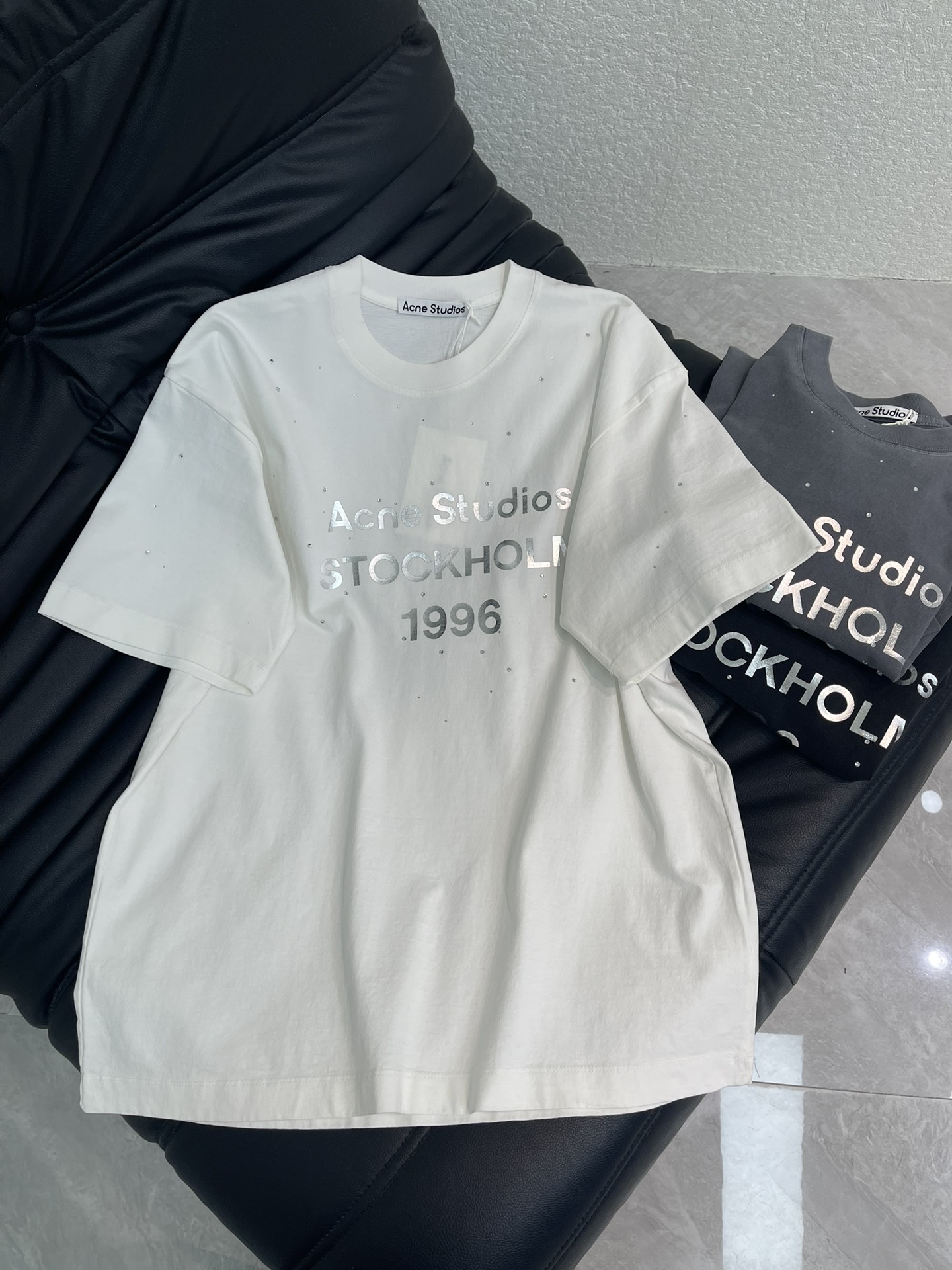 NO:709913,Acne*26 new spring and summer washed and distressed round-neck short-sleeved T-shirt with rhinestones and reflective letters. Decorated with 'Acne Studios 1996' metallic reflective texture bronzing print on the chest, embellished with rhinestone details. Made of washed and distressed pure cotton fabric, with an irregular texture on the surface, creating a retro style. Neutral style, casual and loose fit, hip-length, same style for men and women!  S-XL A,,acne studios,dior,T-shirt,tees,t-shirt,19860909Acne*26春夏新款洗水做旧钉钻反光字母圆领短袖T恤.胸前饰有“Acne Studios 1996”金属反光质感烫金印花,点缀水钻细节.采用洗水做旧纯棉面料,表面呈不规则质感,营造复古风格.中性风格,休闲宽松版型,衣长及臀,男女同款！S-XL A,,acne studios,dior,T-shirt,tees，t-shirt,,Women's clothing