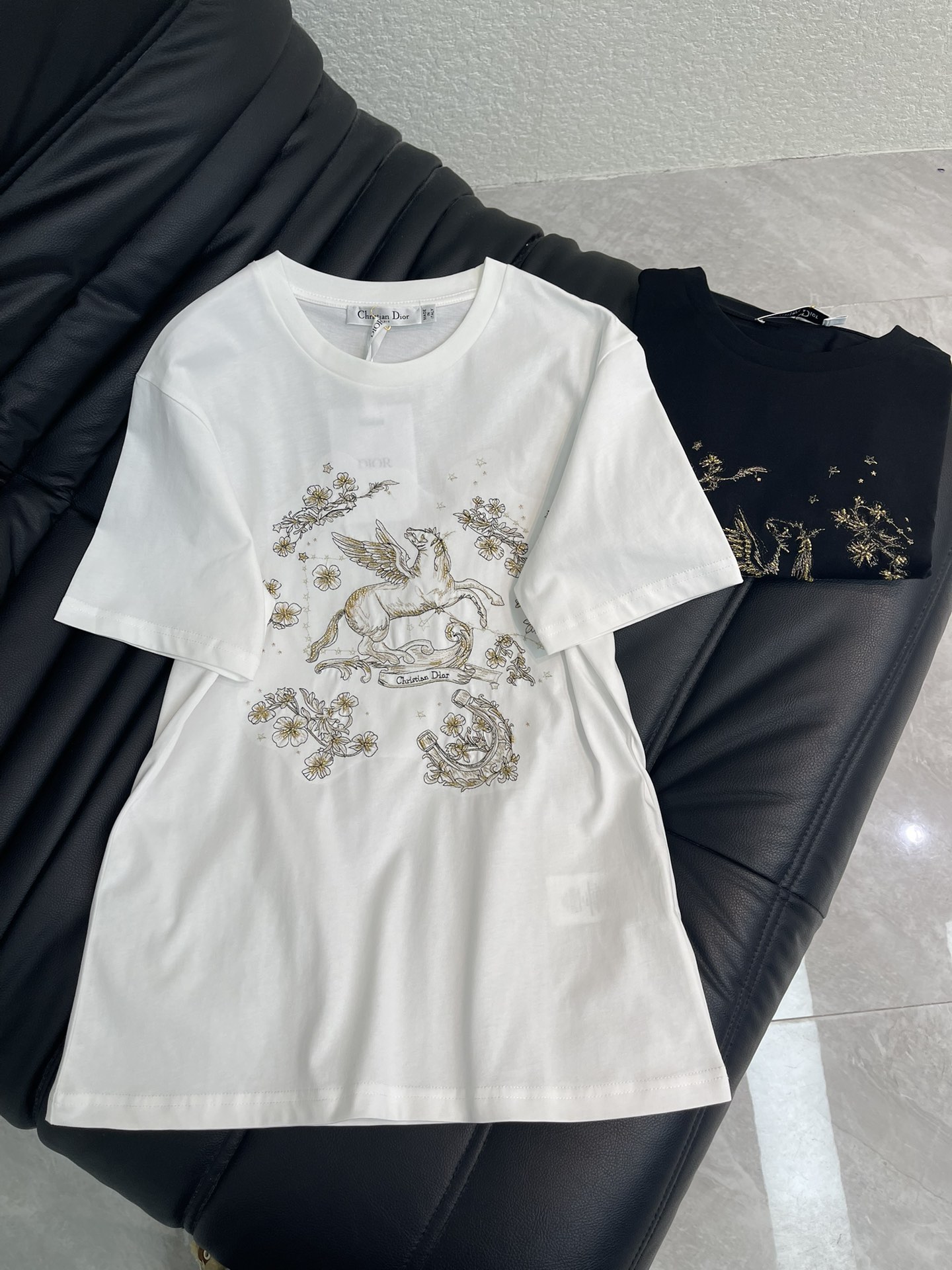 NO:709898,Dio*26 new spring and summer New Year's New Year embroidered Pegasus logo short-sleeved T-shirt. New Year's Series #Customized YB twill cotton material, comfortable texture, stylish to wear, regular short-sleeved shirt cut, black and white, versatile and not picky, gold embroidered Pegasus flowers are delicate and elegant  The exquisite and smart pattern design hides romance. The cotton fabric is soft and elastic and skin-friendly. The basic round neck style is suitable for various body shapes. Wearing it alone is a refreshing daily casual style. Layering it with a suit or denim jacket can unlock rich layers of outfits and is fashionable. SML  A,,dior,jackets & coats,T-shirt,tees,t-shirt,business suit,19860909Dio*26春夏新款贺岁刺绣飞马徽标短袖T恤.新年贺岁系列#定制YB斜纹全棉材质,质感舒适,穿搭有型,常规短袖恤剪裁,黑白两色百搭不挑人,金线刺绣飞马花卉细腻又精致,灵动的图案设计暗藏浪漫,全棉面料软弹亲肤,基础圆领版型适配各种身形,单穿是清爽的日常休闲风,搭西装、牛仔外套叠穿,又能解锁层次丰富的穿搭,洋气时尚.SML A,,dior,jackets & coats,T-shirt,tees，t-shirt,business suit,,Women's clothing