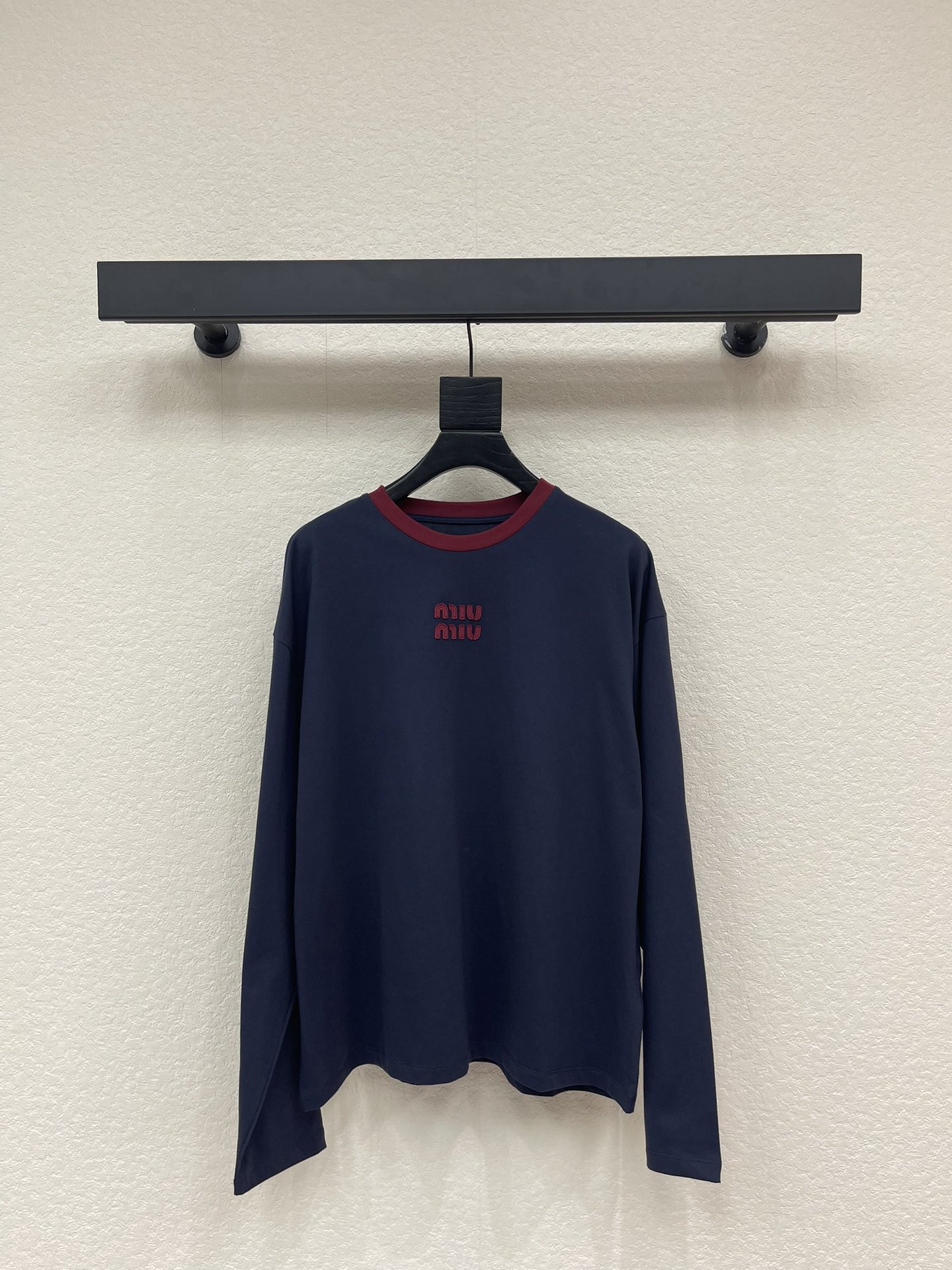NO:709907,Miumi*26 early spring new style contrasting letter logo long-sleeved T. Customized YB native cotton material, soft and skin-friendly, comfortable and stylish, loose silhouette long-sleeved top cut, the collar is edged with threads for contrast, the main tone of deep navy blue is calm and high-end, and the burgundy contrast collar  Echoing the logo of the same color, the details are full of ingenuity. The soft and waxy cotton fabric is skin-friendly and breathable, and the loose off-shoulder version is not flattering on the body shape. Wearing it alone is a casual and lazy style. Layering different items can unlock rich layers of outfits, which is very brand tone. SML  A,,miumiu,19860909Miumi*26早春新款撞色字母徽标长袖T.定制YB原生全棉材质,柔软亲肤,舒适有型,宽松廓形长袖上衣剪裁,领口以螺纹包边撞色,深邃藏蓝主调沉稳又高级,酒红撞色领口与同色系标识相呼应,细节处尽显巧思.软糯的棉质面料亲肤又透气,宽松的落肩版型不挑身形,单穿是随性的慵懒风格,叠穿不同单品,又能解锁层次丰富的穿搭,极具品牌基调.SML A,,miumiu,,Women's clothing