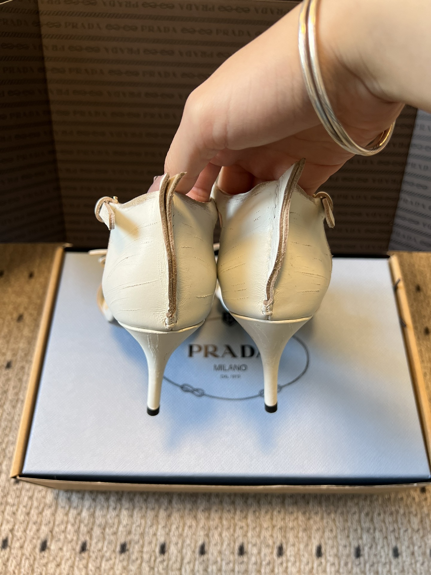 Prad*26ss春夏新款尖头蝴蝶结高跟凉鞋采用尖头和细高跟经典组合，搭配脚踝细带扣设计，鞋头处饰有简约