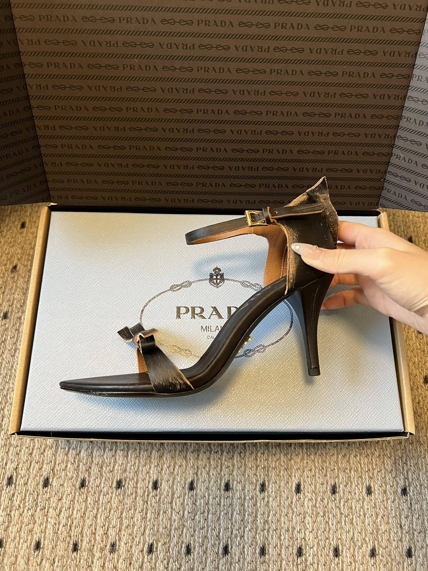 Prad*26ss春夏新款尖头蝴蝶结高跟凉鞋采用尖头和细高跟经典组合，搭配脚踝细带扣设计，鞋头处饰有简约