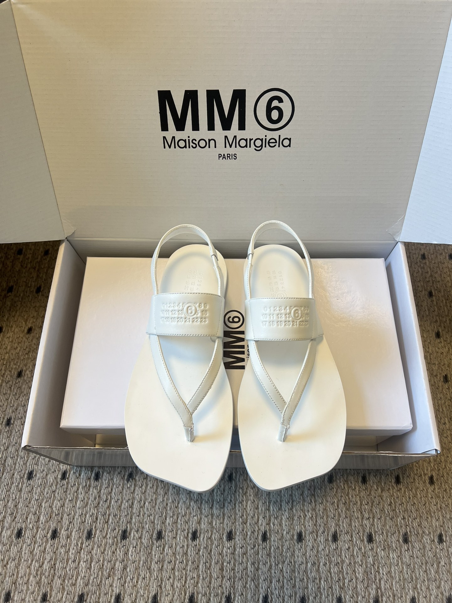 NO:710868,Maison Margiel*26ss new spring and summer flip-flop back strap sandals break the rounded shape of traditional flip-flops and adopt a square toe + clip foot + back strap design. The back strap is adjustable for comfort and wrapping; minimalist lines and geometric square toes create a pioneering deconstructive style, suitable for daily leisure, street fashion and other scenes. The MM6 Maison Margiela brand letter logo is embossed on the ankle strap, and the brand's classic MM6 is printed on the inside of the shoe box.  The logo and full name of the brand, the low-key embossing process is in line with the brand's minimalist and deconstructed design tone, strengthening brand recognition. Sheepskin upper, sheepskin lining, genuine leather outsole, size 35-40 (customized size 40 is non-returnable), heel height 1cm, split-toe shoes, masion margiela, sandals, sheepskin, Leather soles19860909Maison Margiel*26ss春夏新款人字拖后绊带凉鞋 打破传统人字拖的圆润版型,采用方头+夹脚+后绊带设计,后绊带可调节,兼顾舒适度与包裹性；极简的线条搭配几何感方头,打造出先锋的解构主义风格,适配日常休闲、街头潮搭等场景. 脚踝绊带处压印MM6 Maison Margiela品牌字母标识,鞋盒内侧印有品牌经典的MM6 logo与品牌全称,低调的压印工艺契合品牌极简、解构的设计调性,强化品牌辨识度. 鞋面羊皮 内里羊皮 大底真皮大底 size35-40码（40码定制不退换） 跟高1cm,分趾鞋,masion margiela,sandals,sheepskin,Leather soles,Women's Shoes