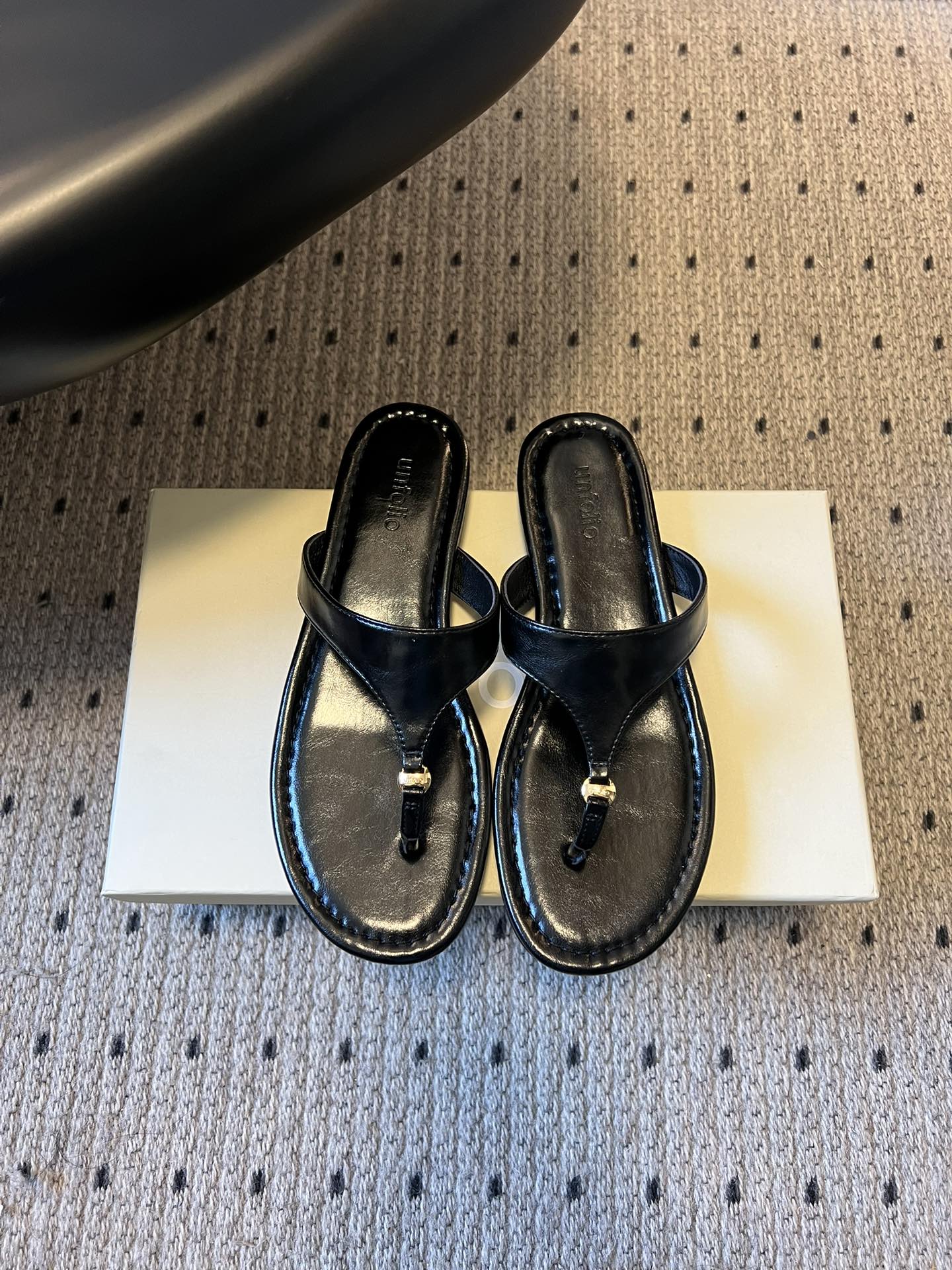 NO:721645,Unfolio 26ss new spring and summer flat flip-flops adopt the basic version of classic flip-flops. The shoe body has simple and neat lines without unnecessary decoration. It is only decorated with metal studs at the toe, which combines a casual feel with exquisite details. The flat-soled design fits the foot shape and is suitable for daily home, vacation and other leisure scenes. The Unfolio brand letter logo is clearly embossed on the inside of the footbed, and the shoe box is a simple solid color design, echoing the minimalist style of the shoes, and reflecting the brand recognition in a low-key manner.  Butter leather upper, sheepskin lining, Italian genuine leather outsole, sizes 35-41 (customized sizes 40 and 41 are non-returnable), heel height 1cm, split-toe shoes, slippers, sheepskin, Leather soles19860909Unfolio 26ss 春夏新款平底人字拖鞋 采用经典人字拖基础版型,鞋身线条简约利落,无多余装饰,仅在夹脚处搭配金属饰钉点缀,兼具休闲感与精致细节；平底设计贴合脚型,适配日常居家、度假等休闲场景. 鞋床内侧清晰压印Unfolio品牌字母标识,鞋盒为简约纯色设计,与鞋履的极简风格相呼应,低调中体现品牌辨识度. 鞋面牛油皮 内里羊皮 大底意大利真皮大底 size35-41码（40、41码定制不退换） 跟高1cm,分趾鞋,slippers,sheepskin,Leather soles,Women's Shoes