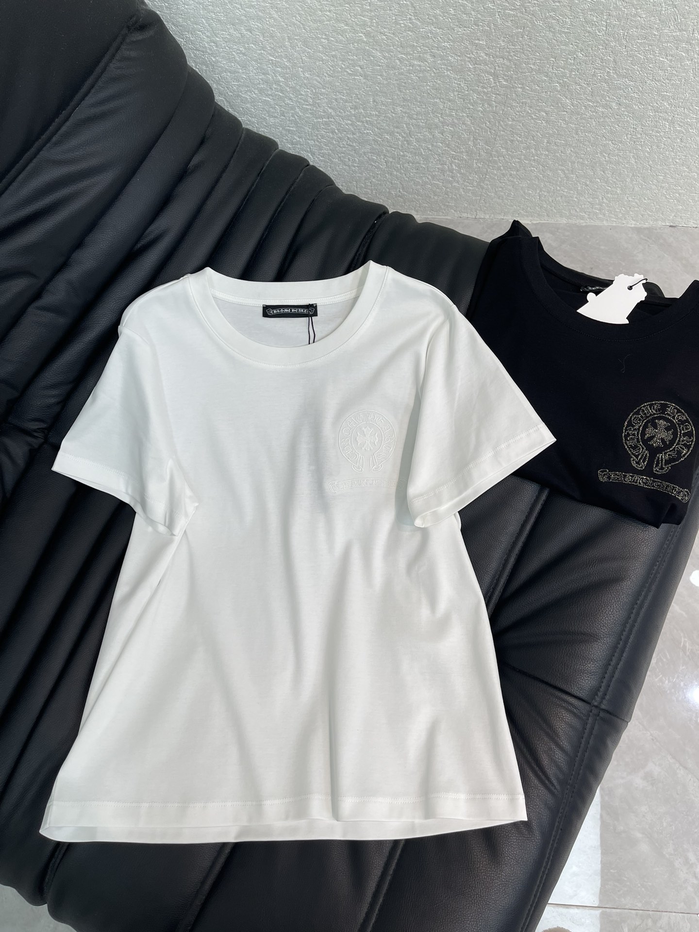 NO:715320,Chrome He*rts 26 spring and summer new embroidered round neck short-sleeved T-shirt!  High-end mercerized cotton fabric, with the iconic cross embroidery as the core, perfectly combines the tough texture of American street style with exquisite craftsmanship. The classic black and white colors are suitable for various dressing scenes. The heavy cotton material has been pre-shrunk, soft and waxy to the touch and not easy to deform. The embroidered logo on the chest uses the same color stitching.  It is low-key and yet recognisable. The round neck design is simple and neat, and the slim fit fits the body shape without being tight. Whether worn alone to create a casual street style, or worn as a layered shirt or sweatshirt, you can easily show off your good taste in early spring. It is an evergreen wardrobe that can accompany you for many years. SML  A,,chrome hearts,chrome hearts,hoodie,sweatshirts,shirts,T-shirt,tees,t-shirt,19860909Chrome He*rts 克罗心26春夏新款刺绣圆领短袖T恤！高订丝光棉面料,以标志性的十字花刺绣为核心,将美式街头的硬朗质感与精致工艺完美融合.经典黑白两色适配各种穿搭场景,重磅棉料经过预缩水处理,触感软糯且不易变形.胸前的刺绣徽标采用同色系线迹,低调中暗藏辨识度,圆领设计简约利落,修身版型贴合身形却不紧绷.无论是单穿打造随性的街头风,还是作为内搭叠穿衬衫、卫衣,都能让你在早春轻松彰显不俗品味,是一件可以陪伴你多年的衣橱常青款.SML A,,chrome hearts,chrome hearts,hoodie,sweatshirts,shirts,T-shirt,tees，t-shirt,,Women's clothing