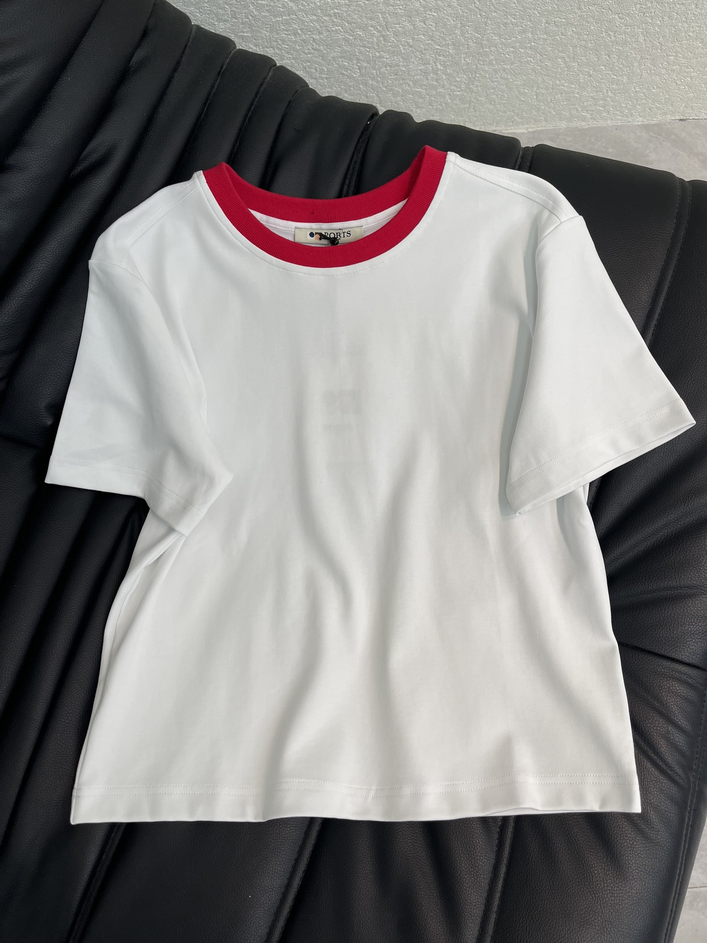 NO:715547,PORT*26 new spring and summer solid color contrast collar pony pendant short-sleeved T-shirt | Exclusively developed by yb!  Top quality production!  With pure white as the base and fiery red as the contrasting collar, it reshapes the classic college style. The fine cotton material is skin-friendly and breathable, and the loose-shouldered silhouette is suitable for various body shapes. The drawstring design on the back and the pony pendant are the finishing touches - the adjustable drawstring adds casualness, and the red and white pony pendant echoes the contrasting color of the collar, low-key and shows the ingenuity. Whether it is paired with jeans to create a relaxed daily feel, or combined with a skirt to interpret elegance and vitality, it can become a versatile textured item in the early spring wardrobe. SML  A,,skirts,jeans,T-shirt,tees,t-shirt,19860909PORT*26春夏新款 净色撞色领小马吊坠短袖T恤丨独家yb开发！顶级高版出品！以纯净白为底,炽热红为撞色领边,重塑经典学院风.细腻棉料亲肤透气,宽松落肩版型适配多元身形,后身的抽绳设计与小马吊坠是点睛之笔——可调节抽绳增添随性感,红白色小马吊坠呼应领口撞色,低调彰显巧思.无论是搭配牛仔裤打造松弛感日常,还是与半裙组合诠释优雅活力,都能成为早春衣橱里的百搭质感单品.SML A,,skirts,jeans,T-shirt,tees，t-shirt,,Women's clothing